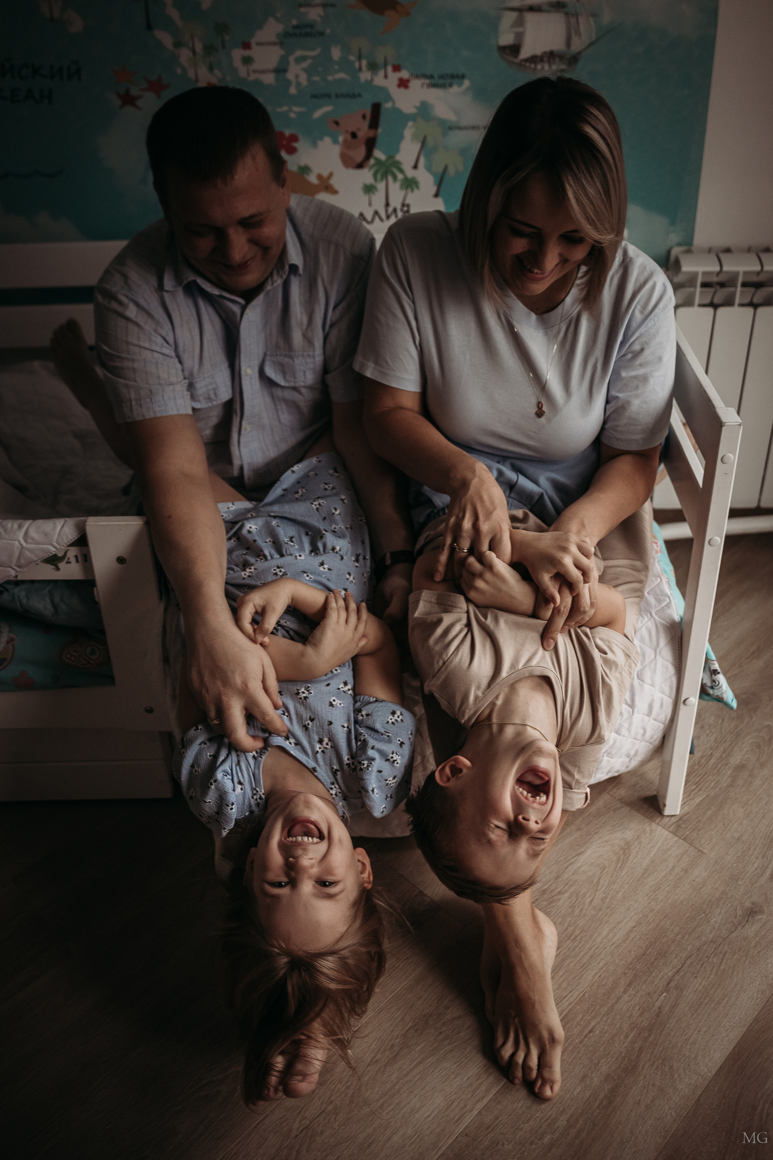 мама и папа щекотят на руках сына и дочку домашняя съёмка