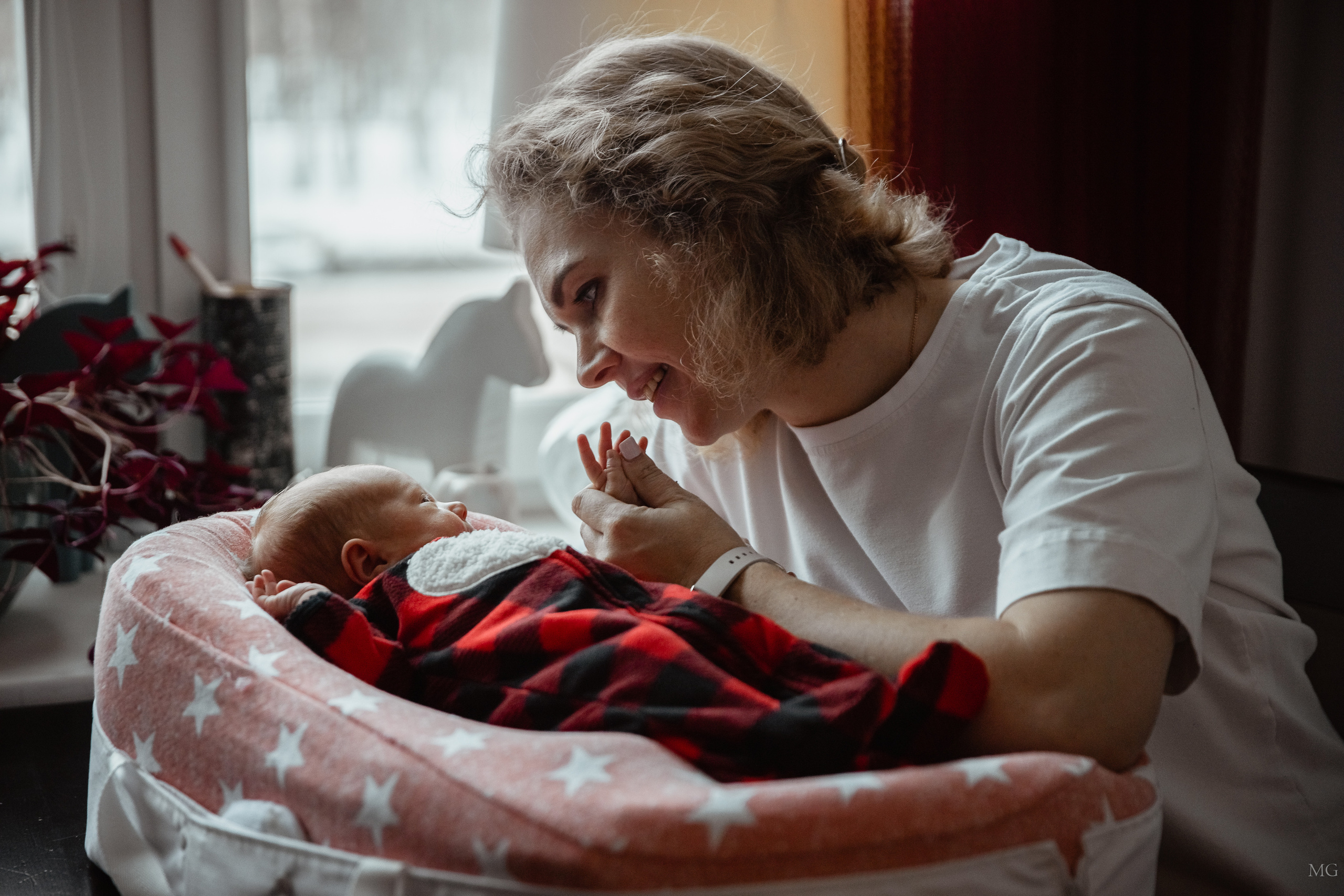 нежная домашняя съёмка семьи с новорожденным мама любуется малышкой