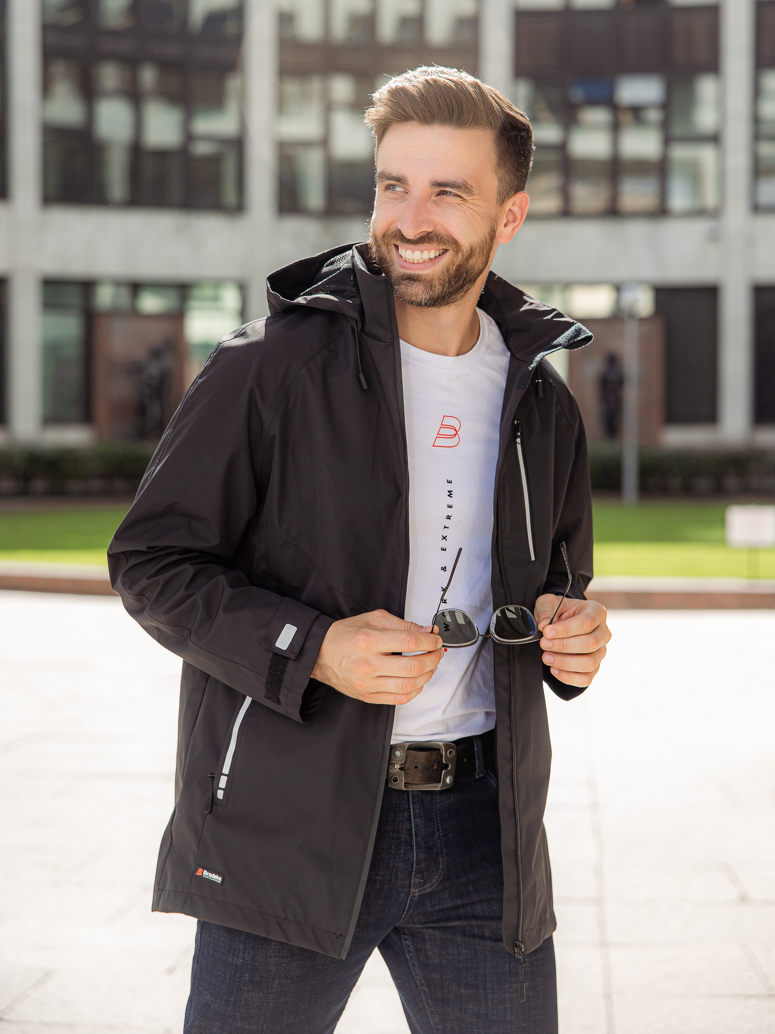 Мужчина с бородой в черной куртке ветровке