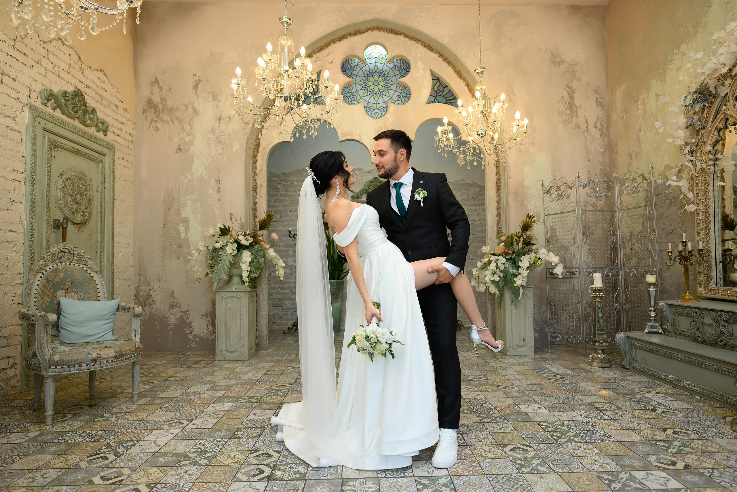 Жених поддерживает невесту за ногу.