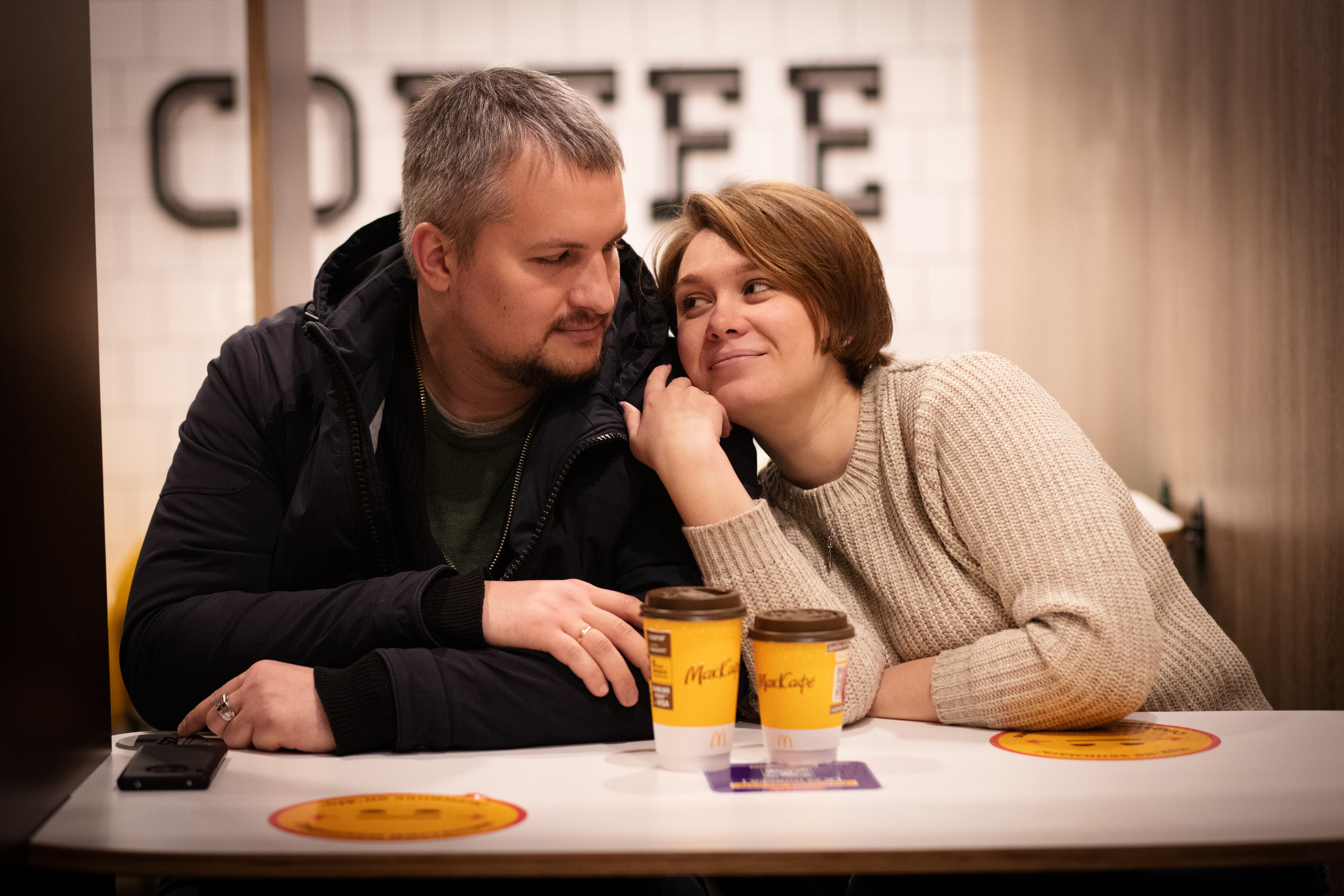 Девушка и парень в кафе пьют кофе.