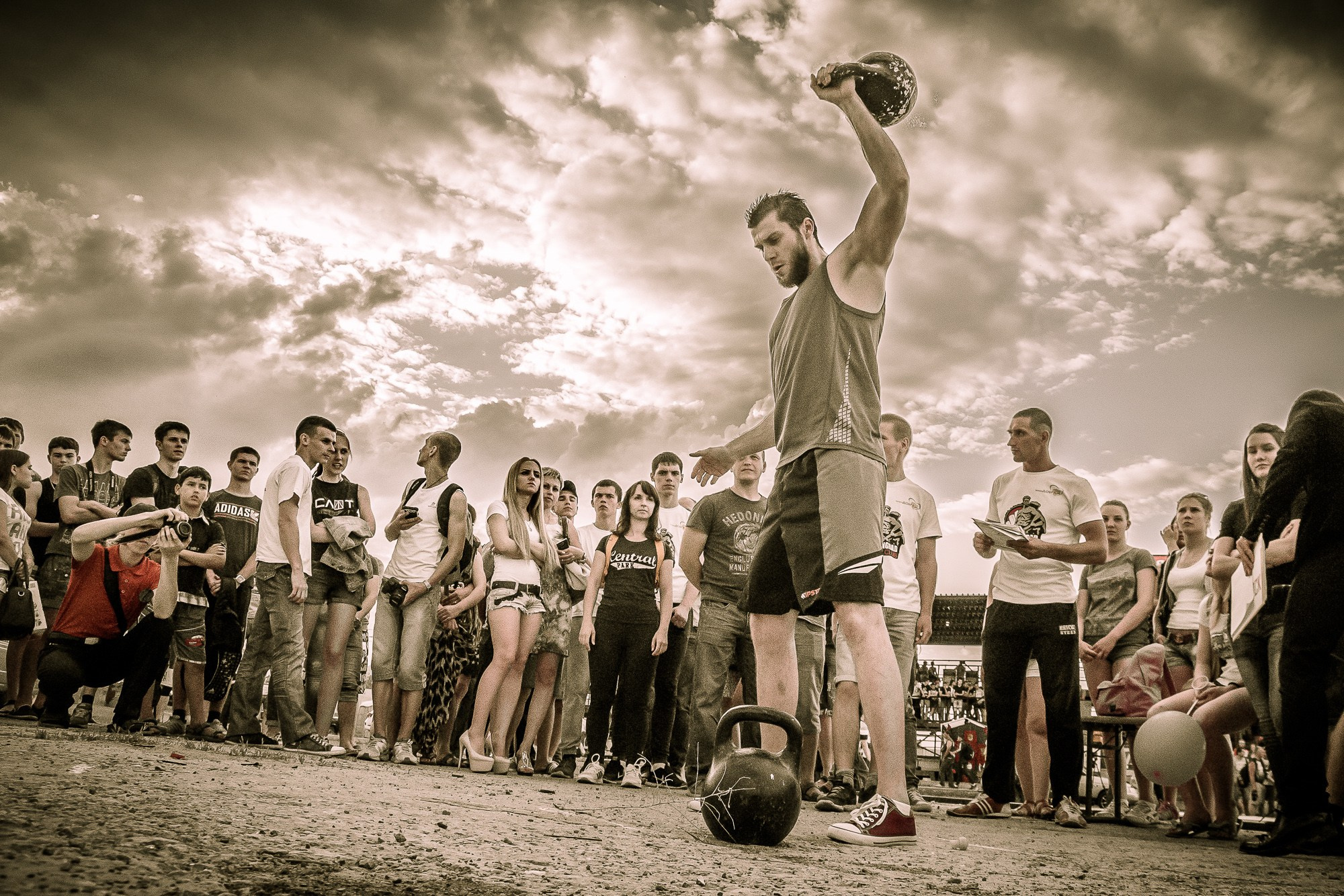 Спортсмен держит гирю над головой dj время соревнований