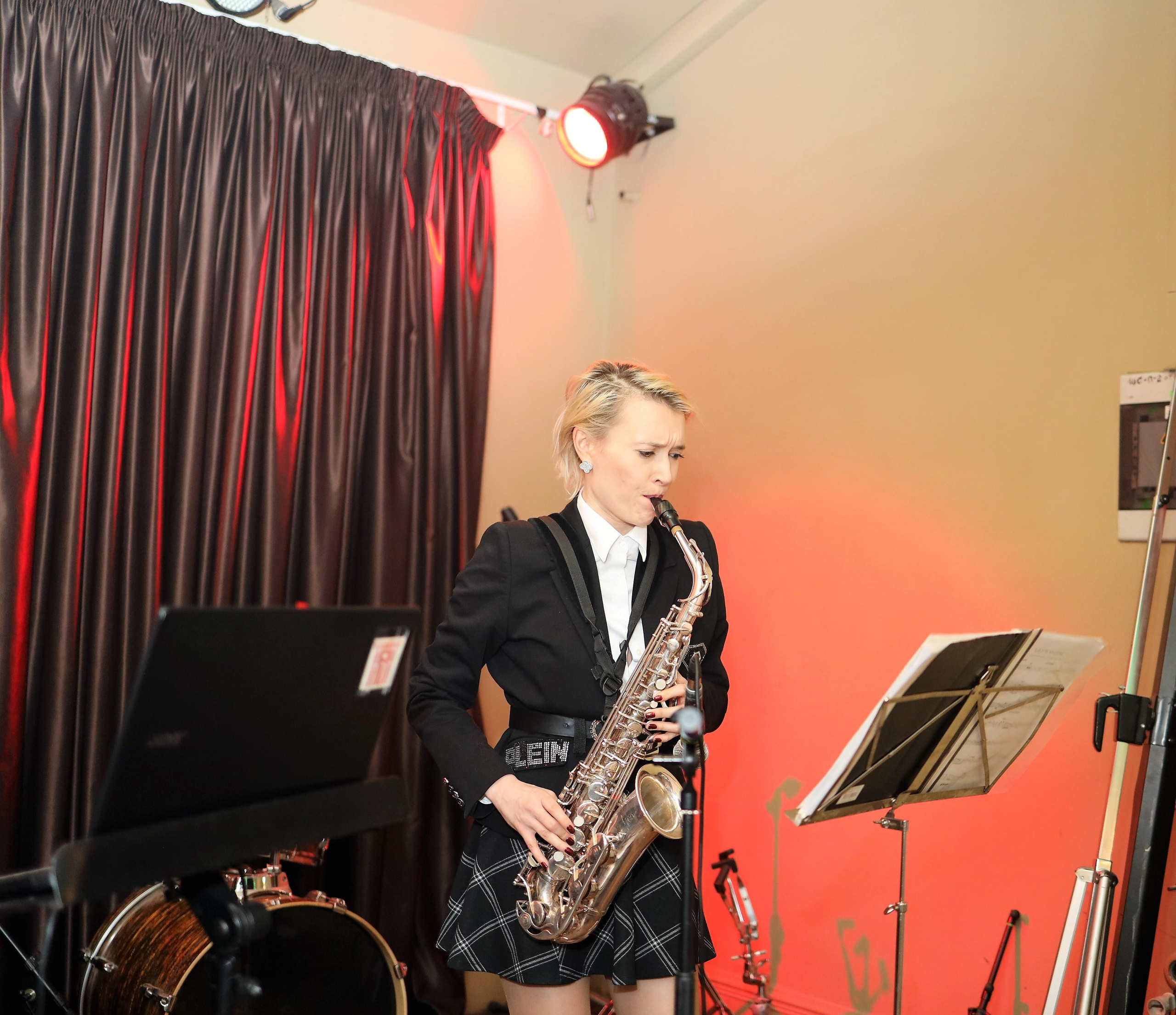 Девушка играет на саксофоне на сигарной вечеринке.