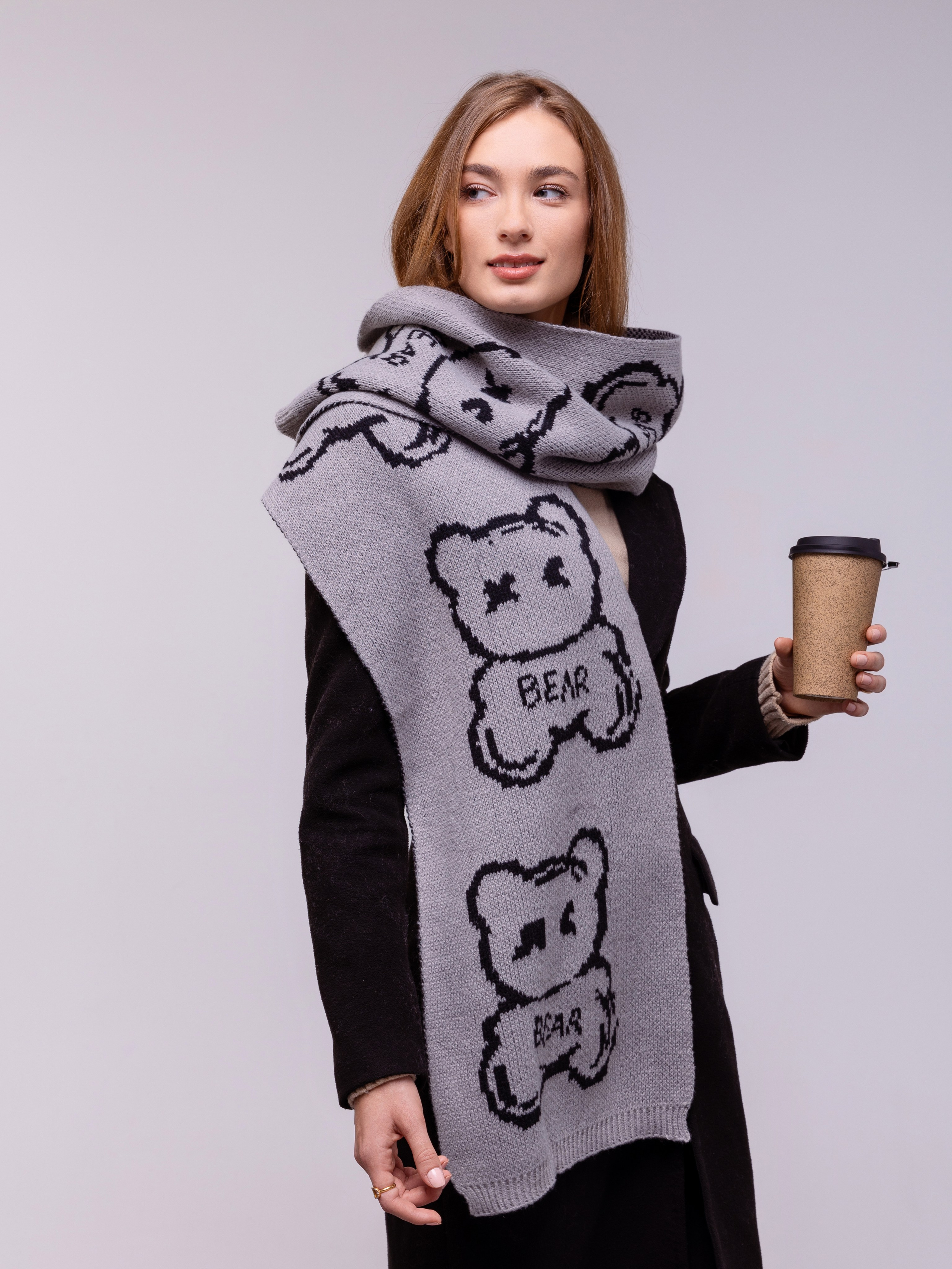 На девушке голубой палантин с крупными рисунками кошек.