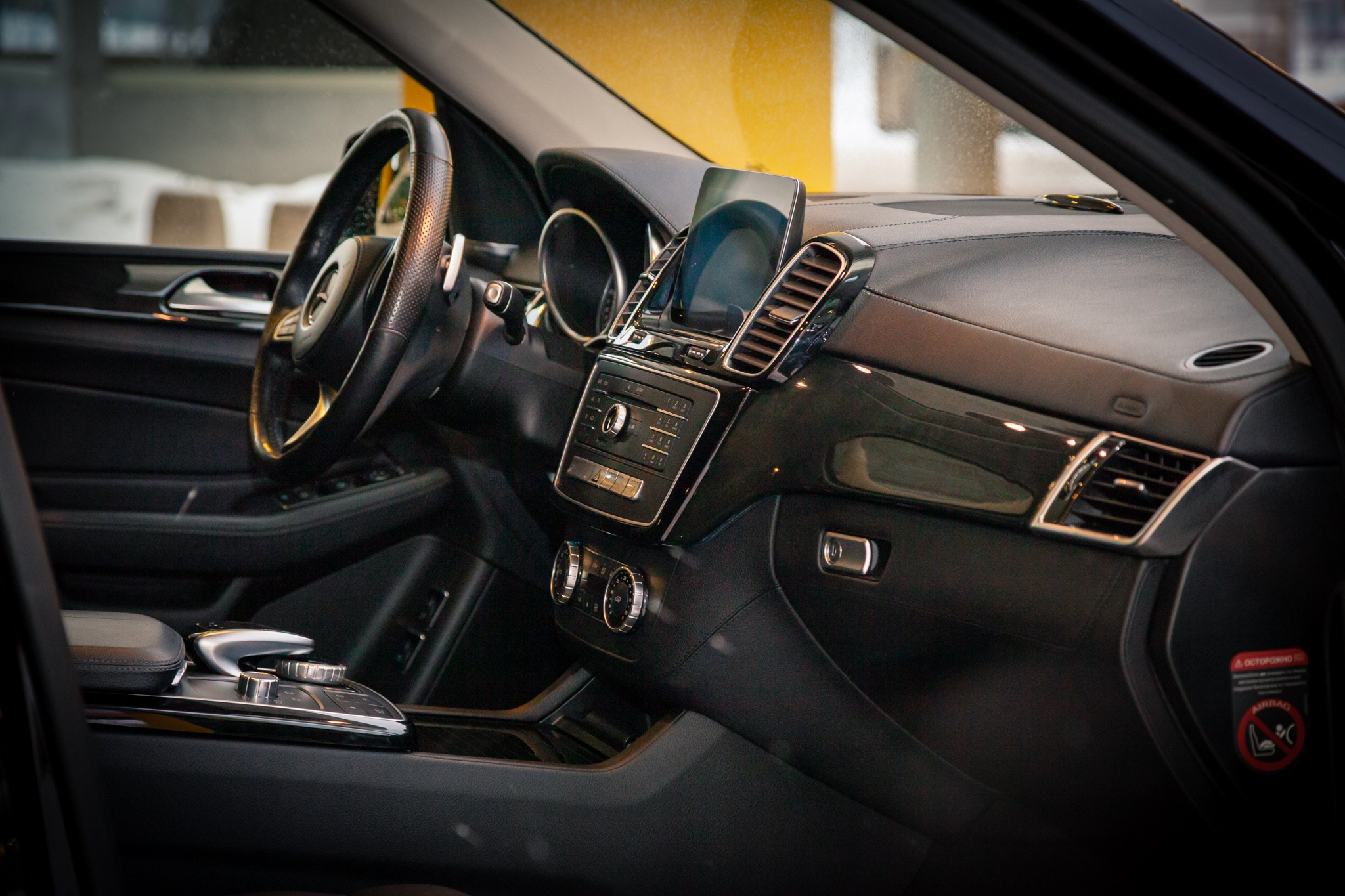 Общий вид интерьера Mercedes-Benz, демонстрирующий рулевое колесо, приборную панель и центральную консоль. Стильный и комфортный салон