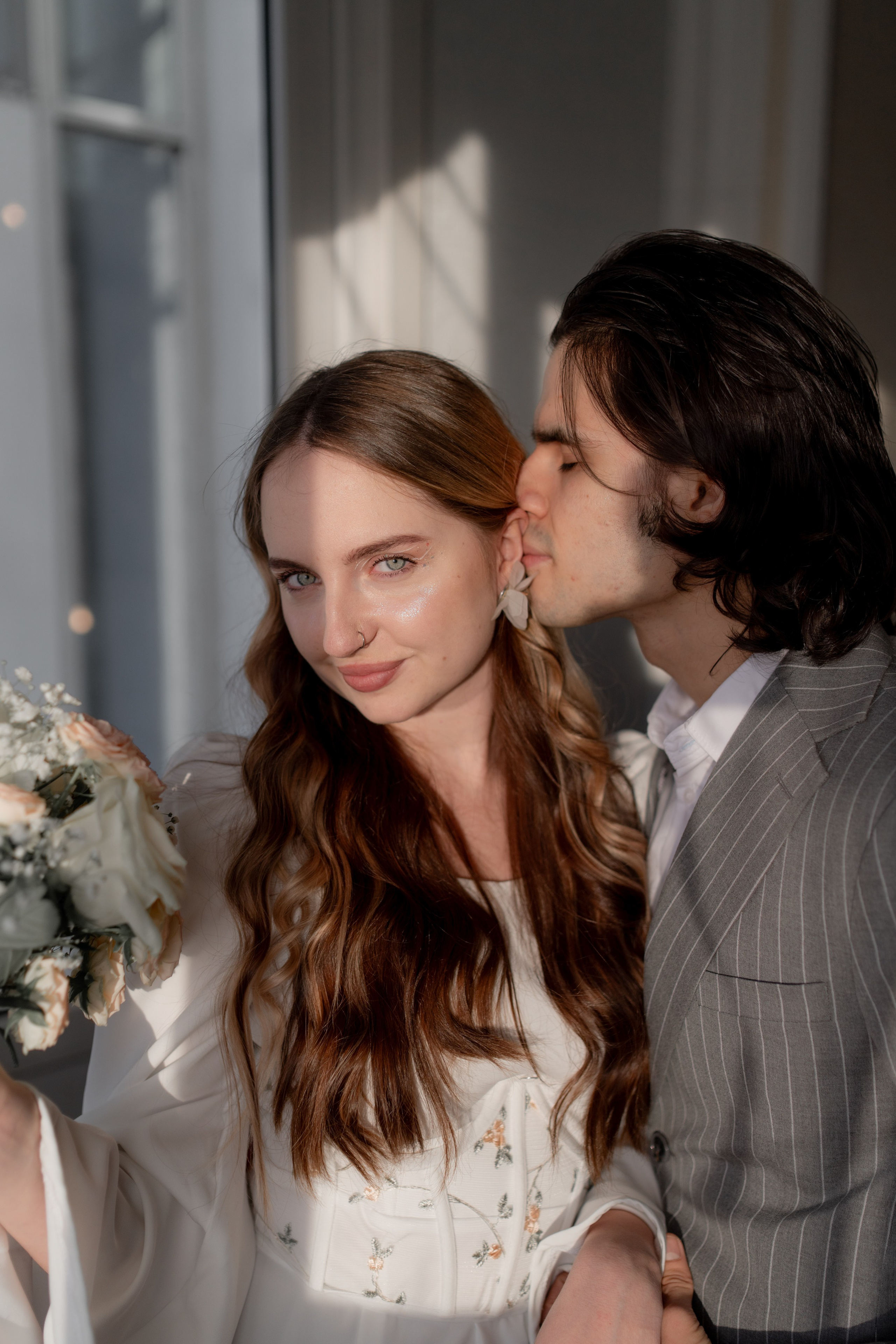 Жених и невеста целуются на в загсе Невского района на свадебной фотосессии