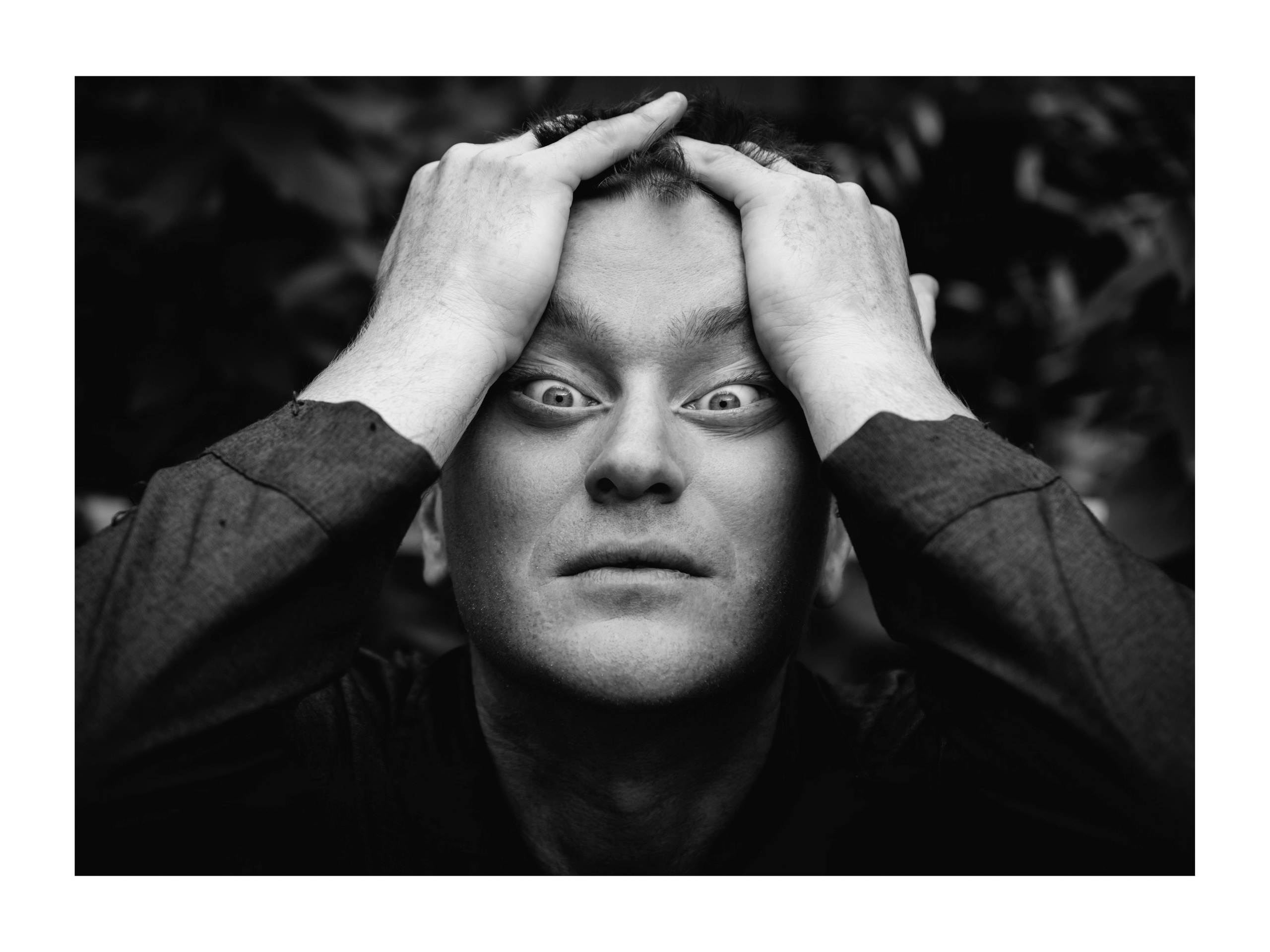 мужчина растягивает глаза в стороны