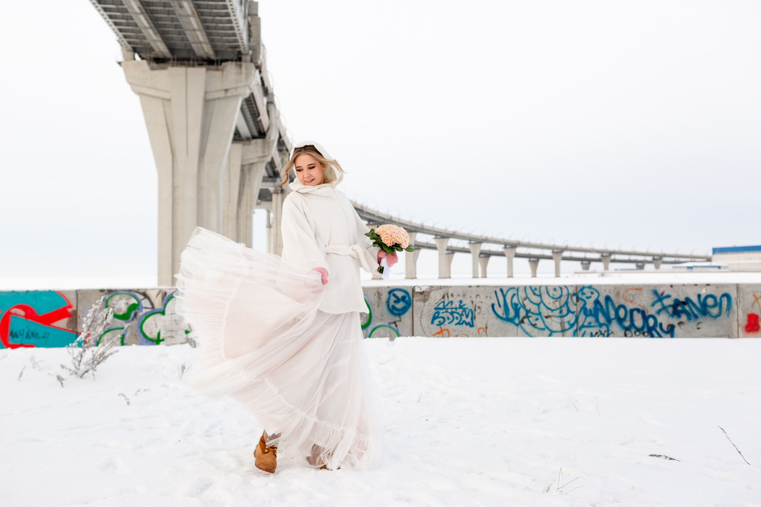 Свадебная фотосессия зимой в Санкт-Петербурге, невеста с букетом на фоне снега