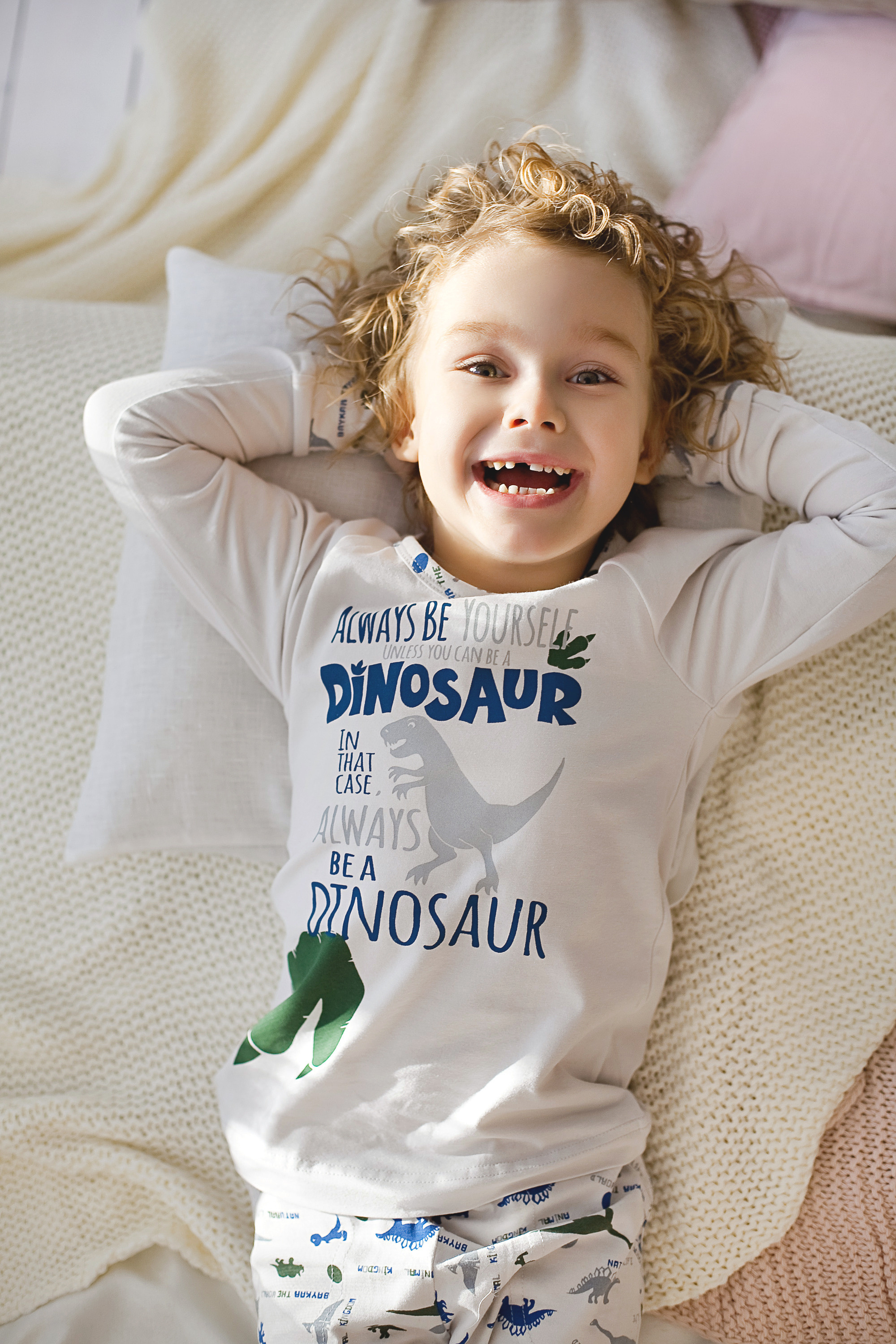 веселый кудрявый мальчик в пижаме