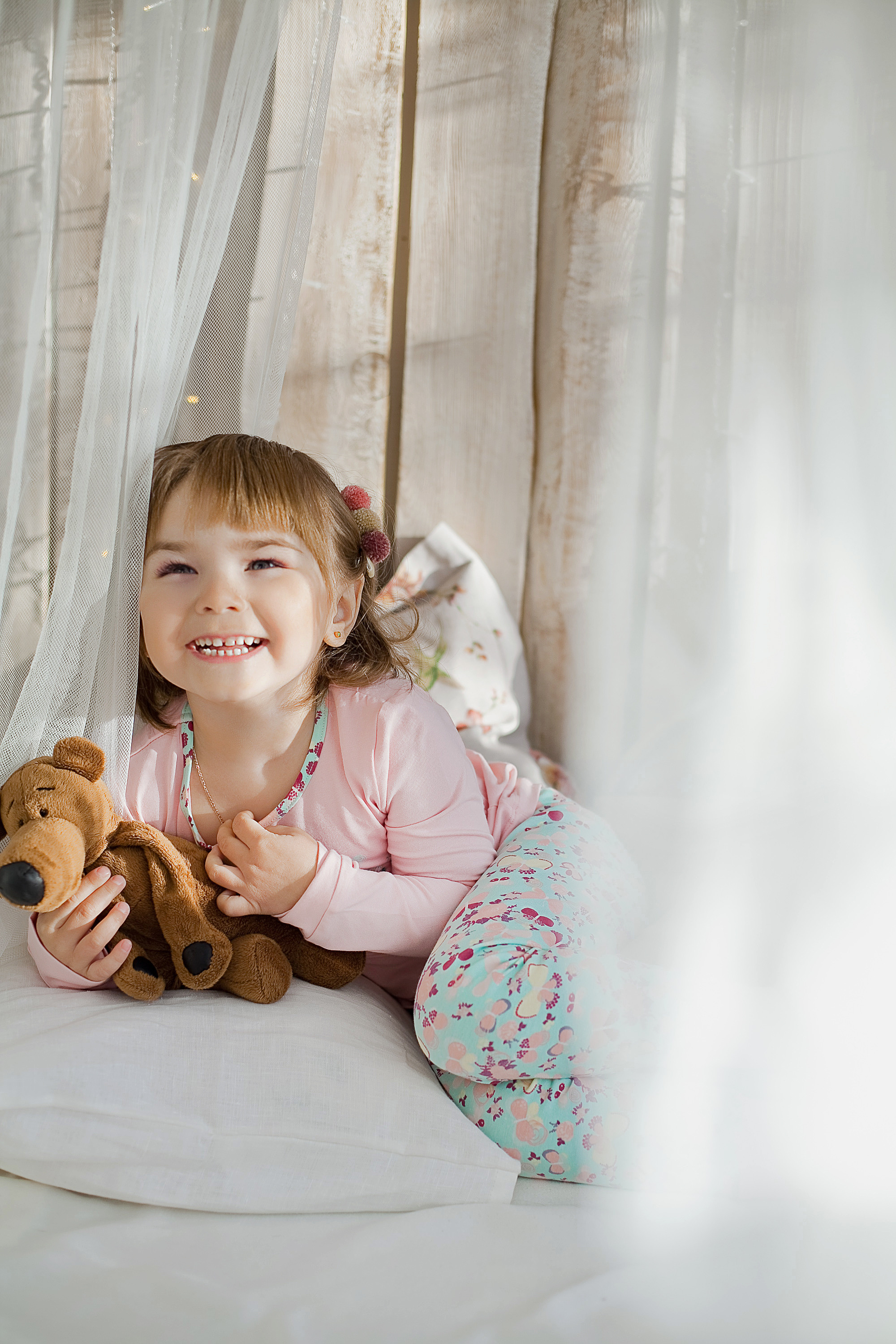 веселая девочка с мягкой игрушкой