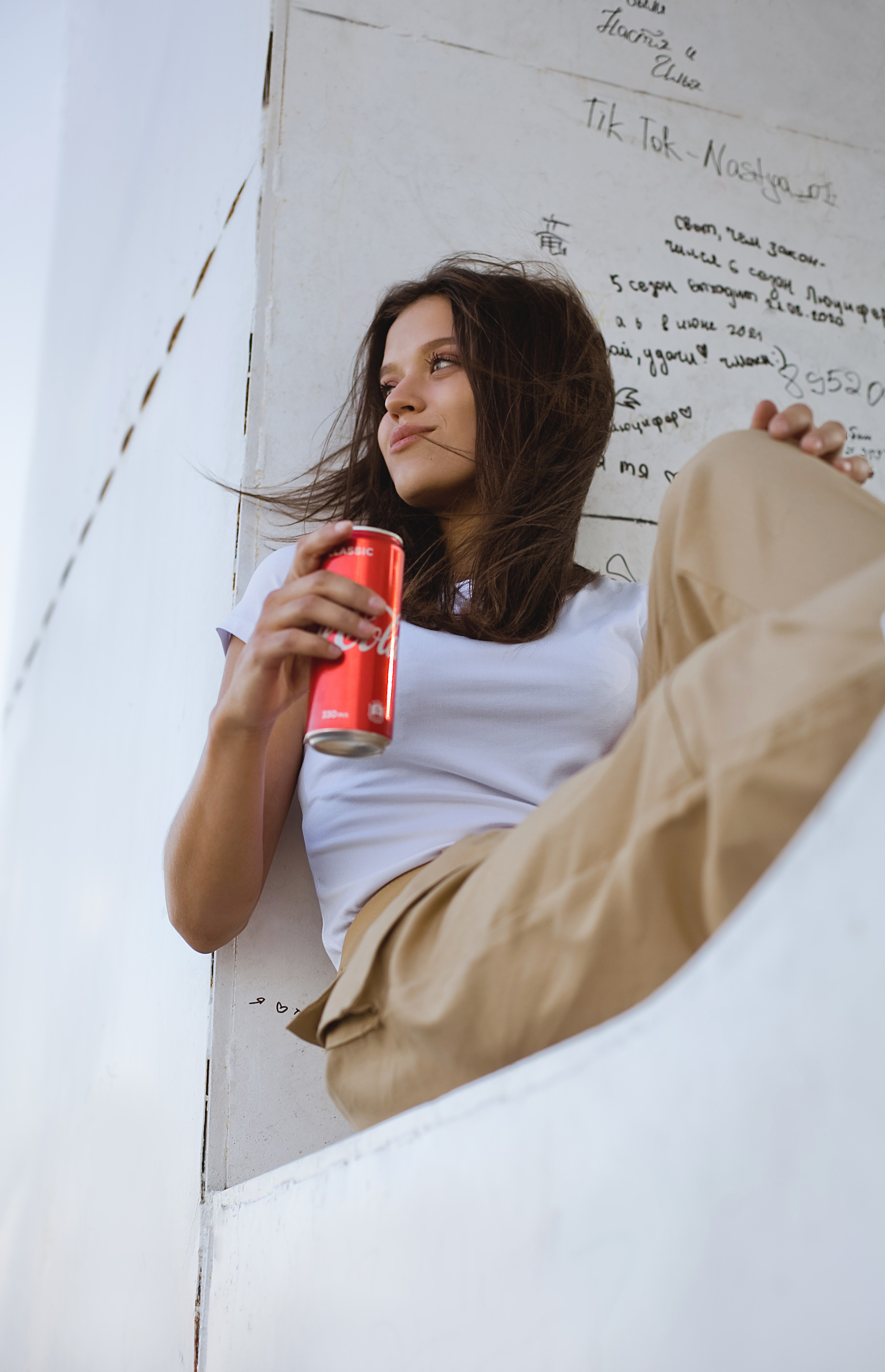 девушка держит банку Coca-Cola