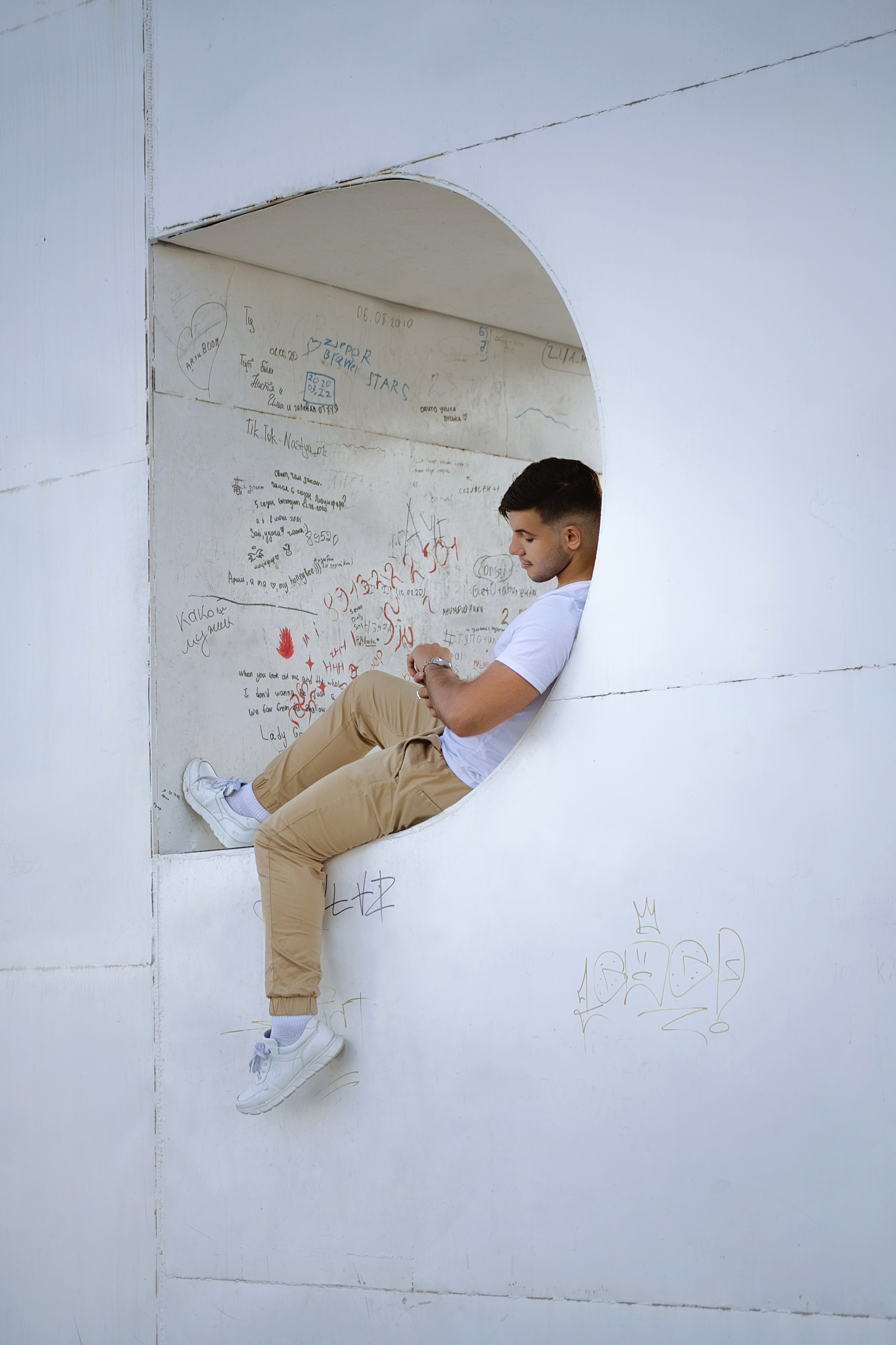 парень ждет девушку на свидание и смотрит на часы