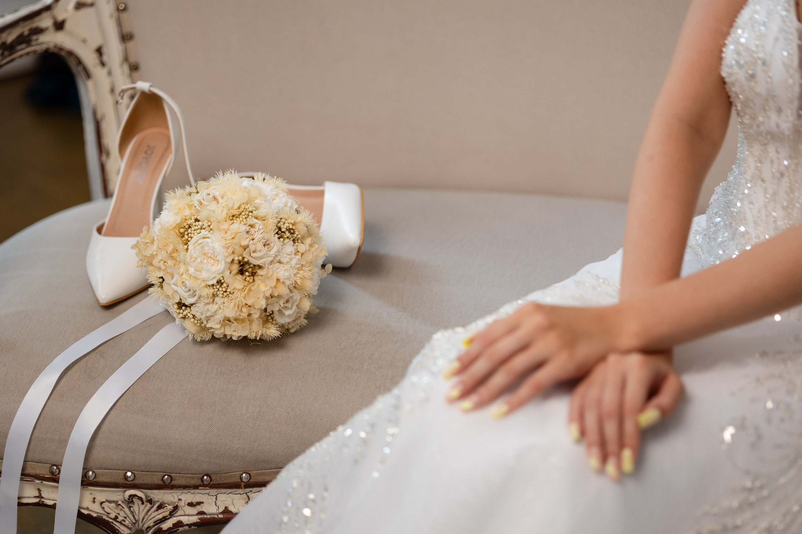  Невеста диване со скрещенными на коленях руками. 