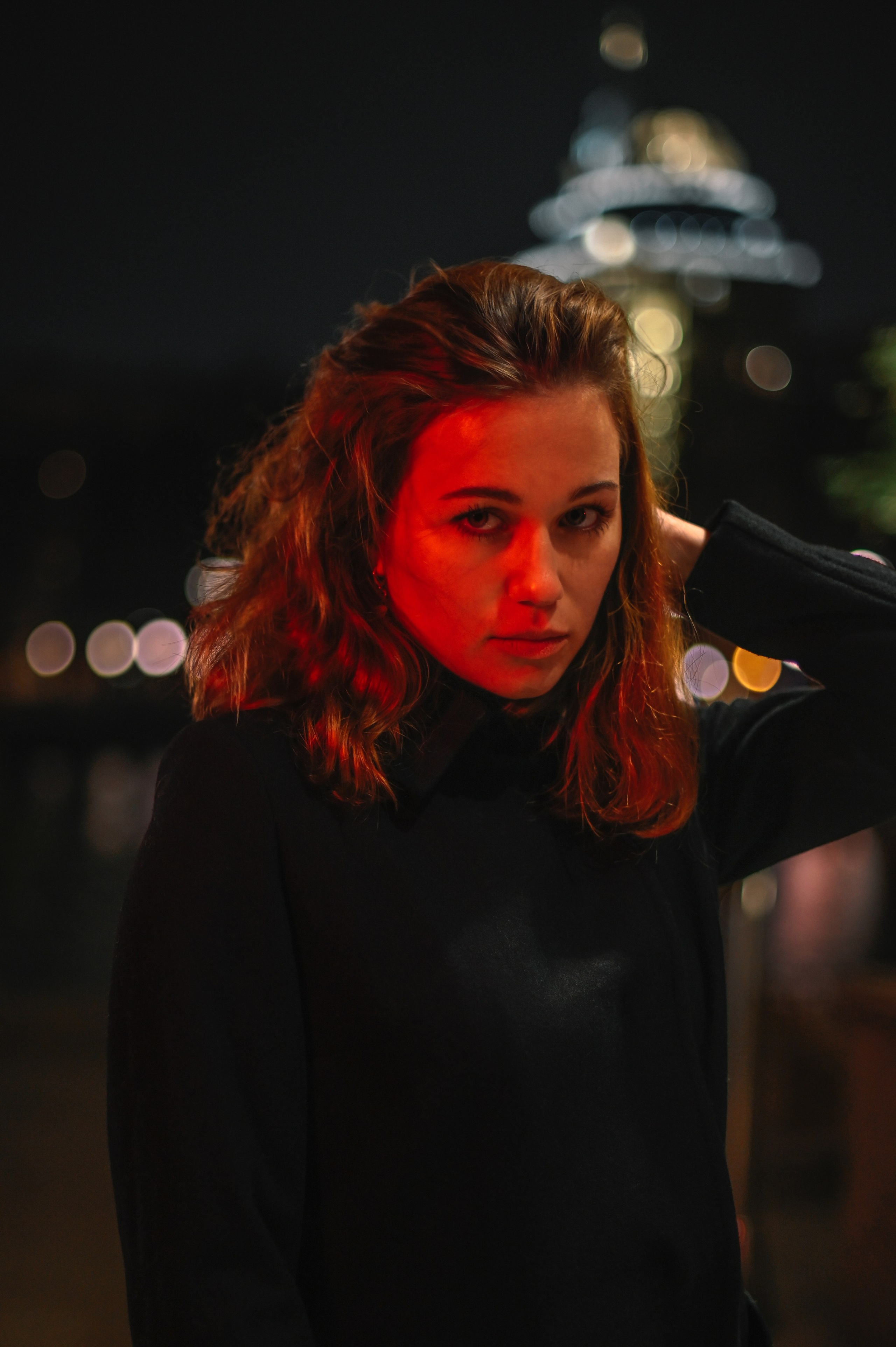 Ночной портрет девушки с волнистыми рыжими волосами, снятый в Москве с эффектными городскими огнями.