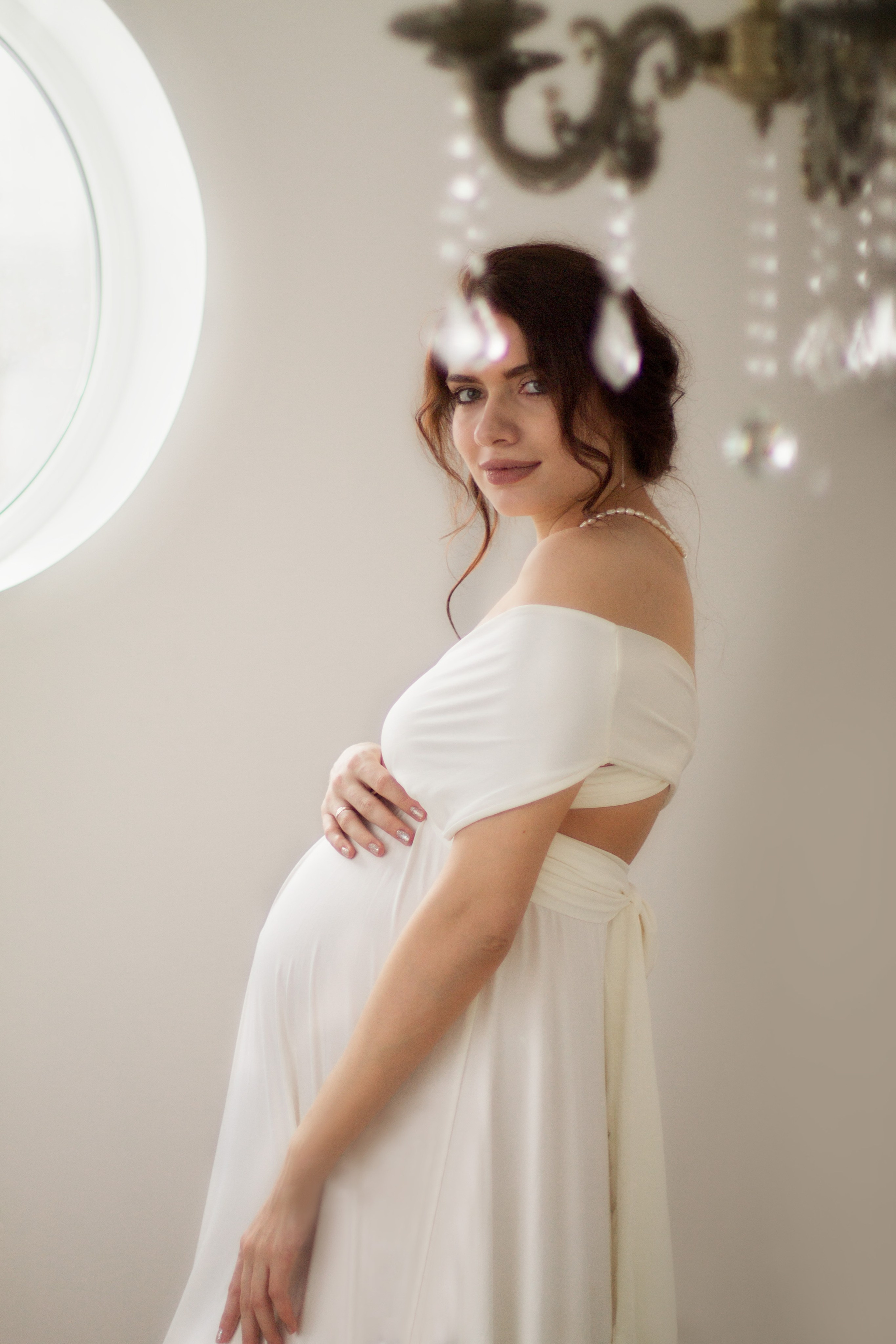 Фотосессия беременности, съёмка беременности в студии, беременная девушка в белом платье