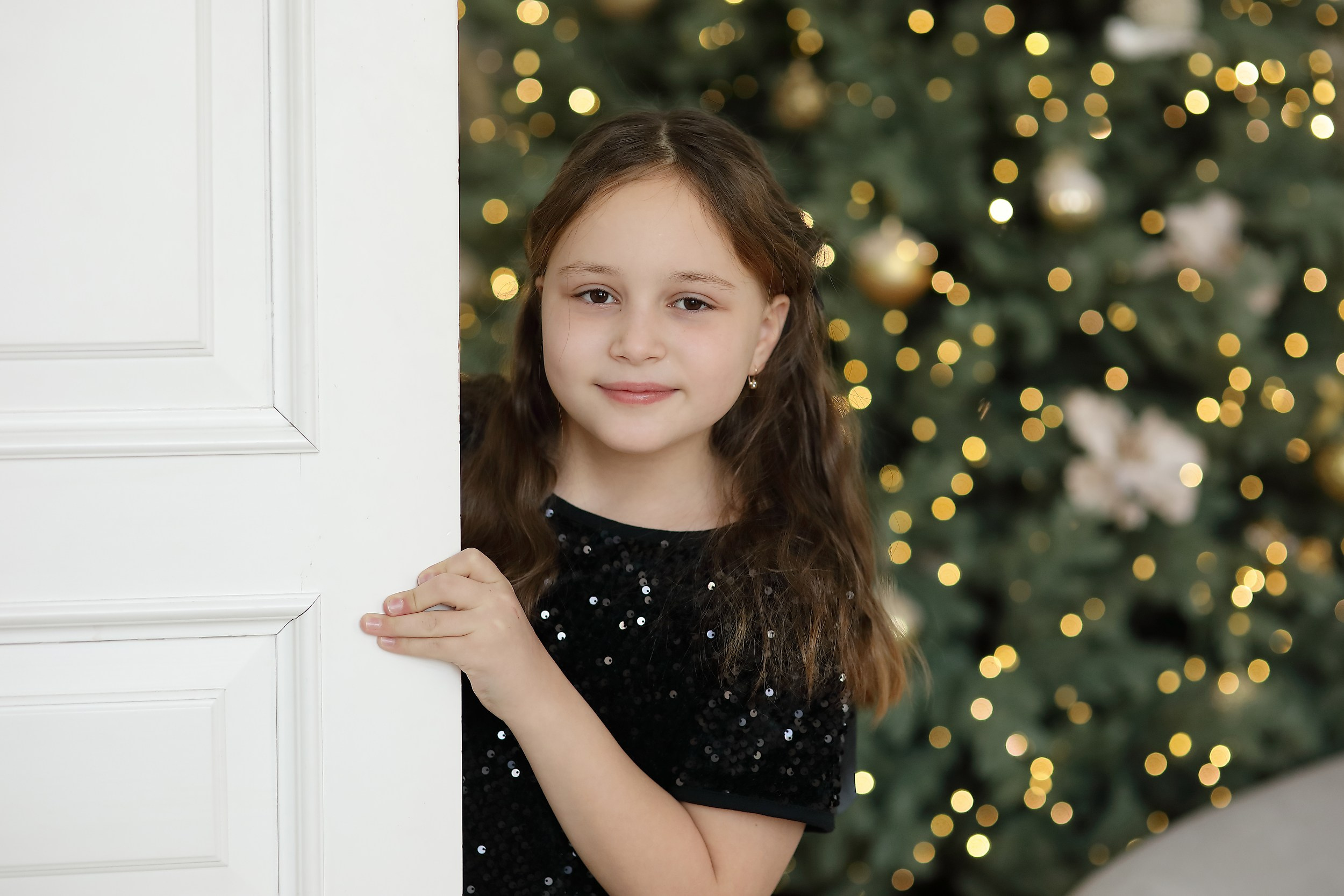 девочка возле двери на фоне ёлки