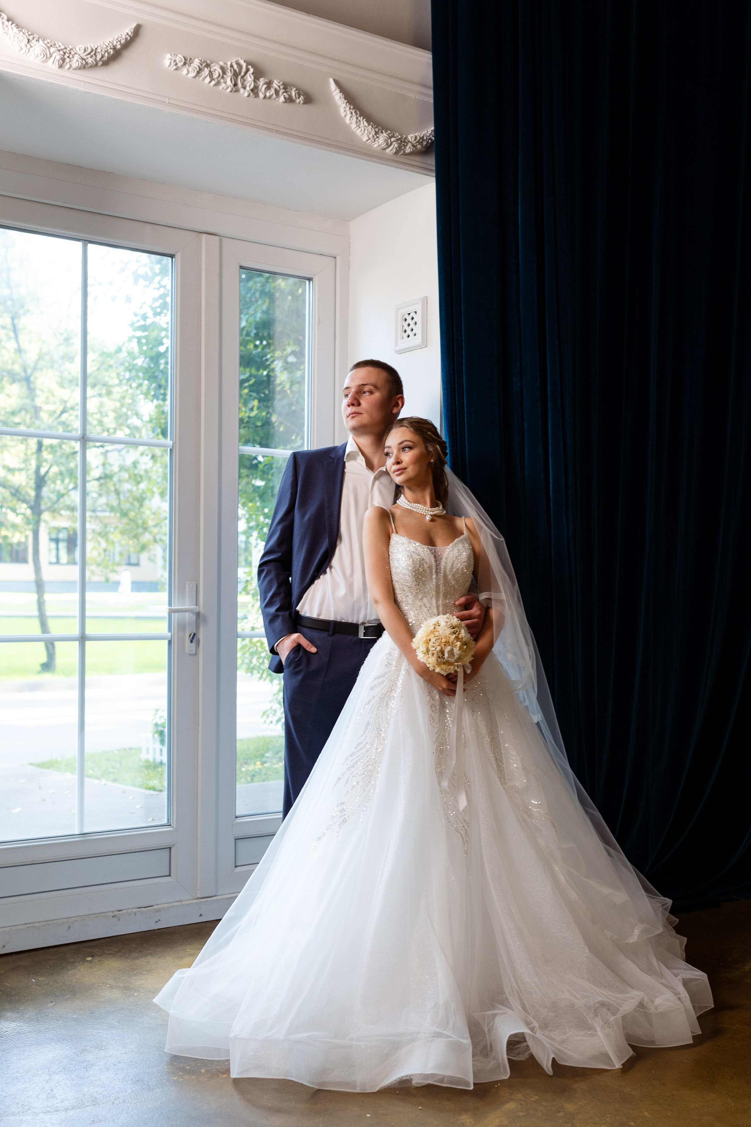 Невеста с букетом цветов прижалась к возлюбленному.