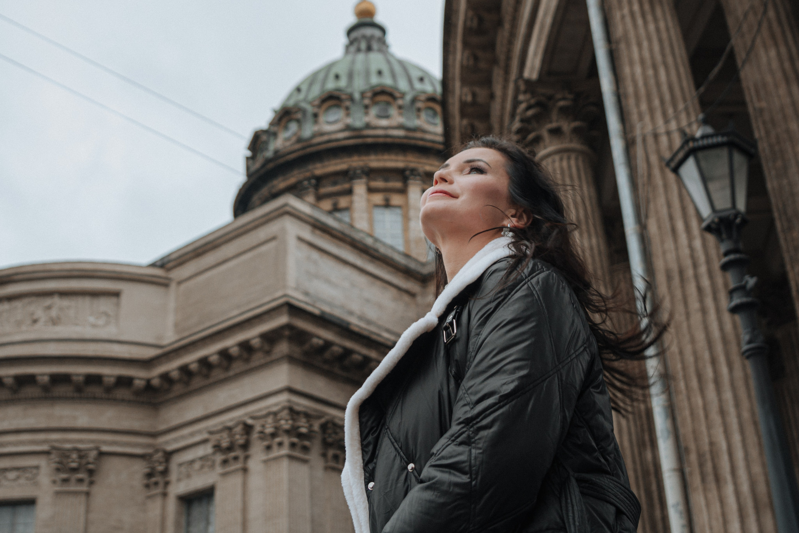 Девушка в своем стильном осеннем наряде прогуливается по улочкам Санкт-Петербурга, наслаждаясь прекрасной погодой и уникальной атмосферой города. Она ощущает мягкий осенний ветер, который ласкает ее лицо, и наслаждается прогулкой в окружении красивых фасадов