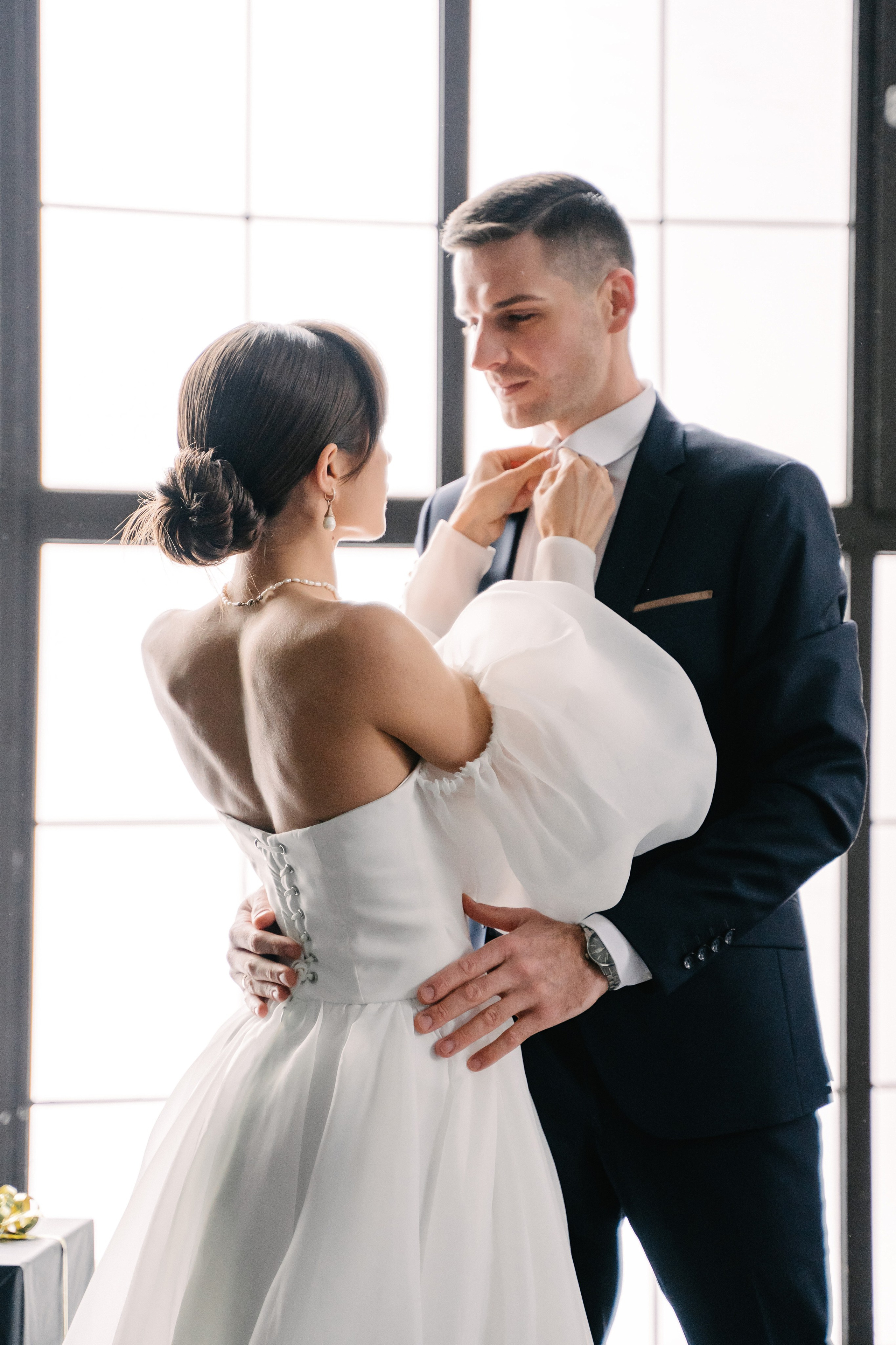 невеста поправляет галстук жениху