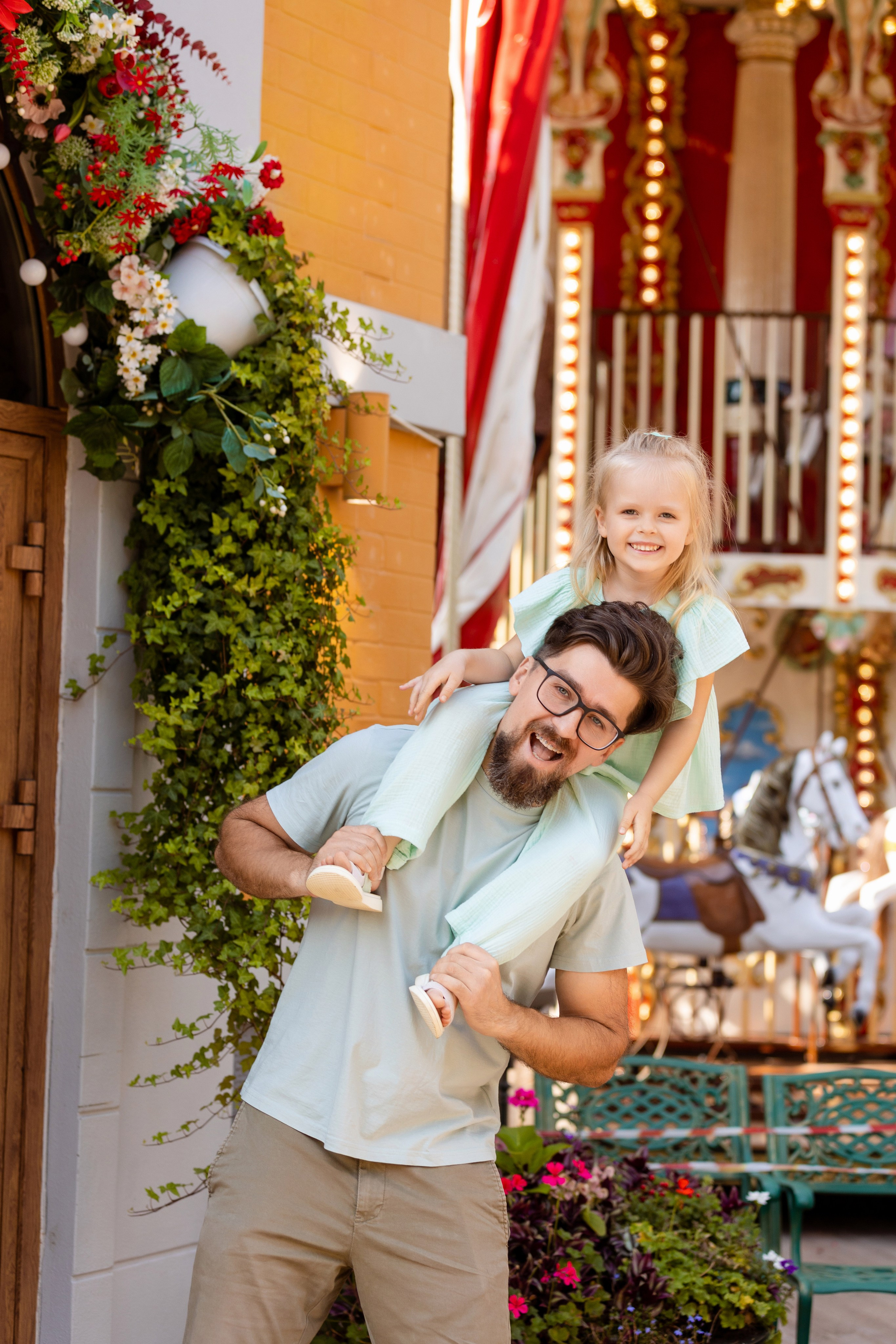 Папа держит на плечах дочь которая смеётся от счастья