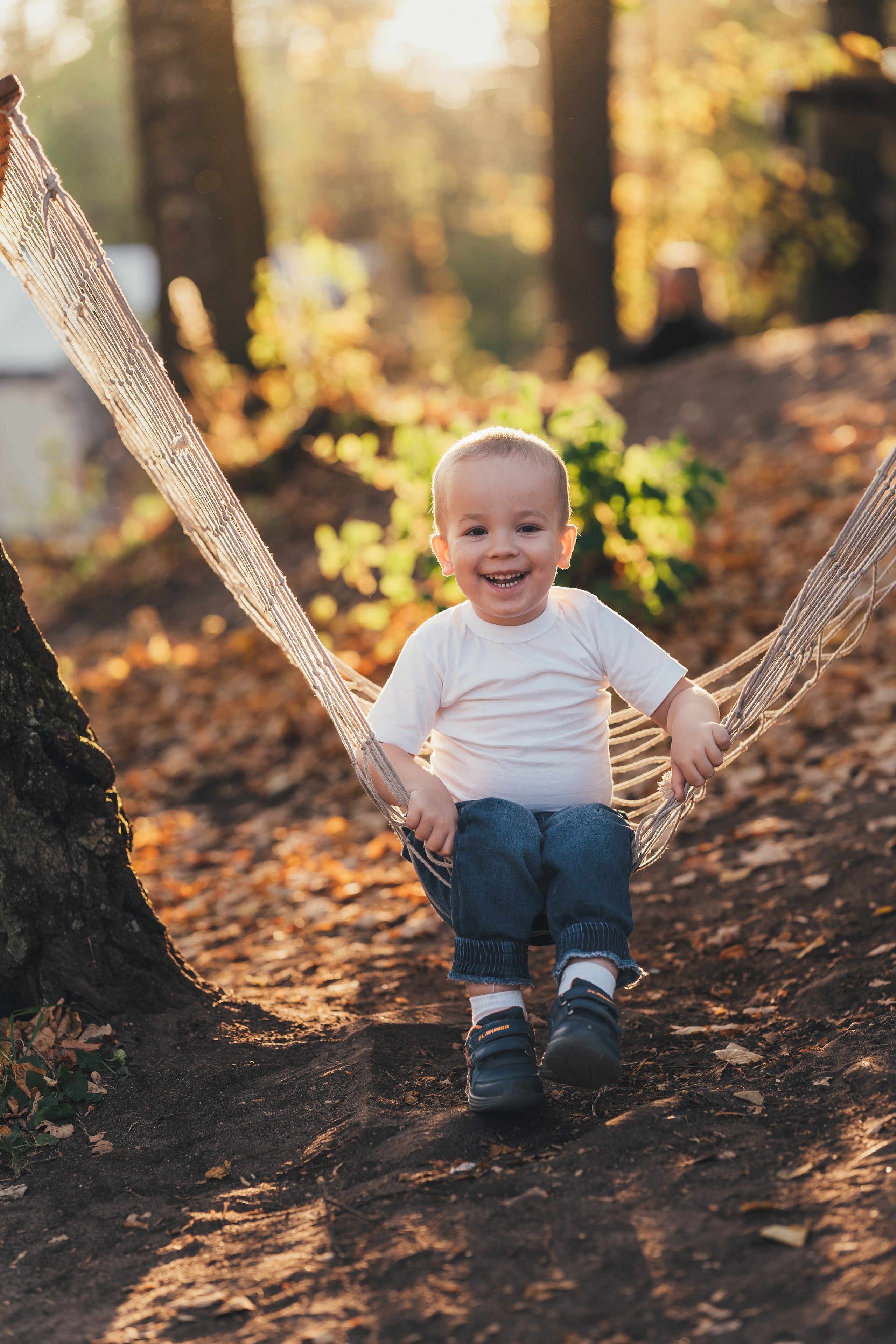 Маленький мальчик в гамаке смеется