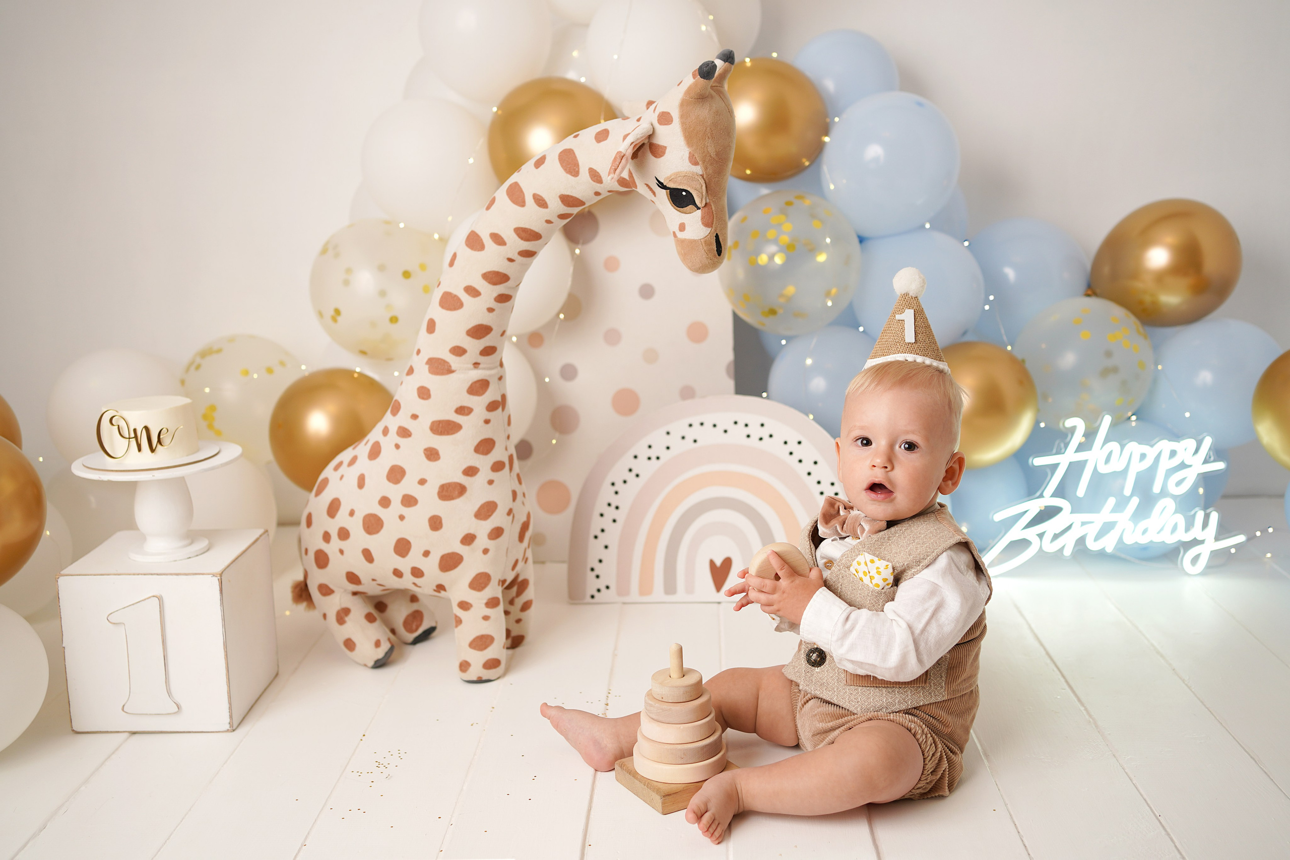 Малыш в красивом костюмчике и колпачке. Рядом надпись С днем рождения, голубые шарики.