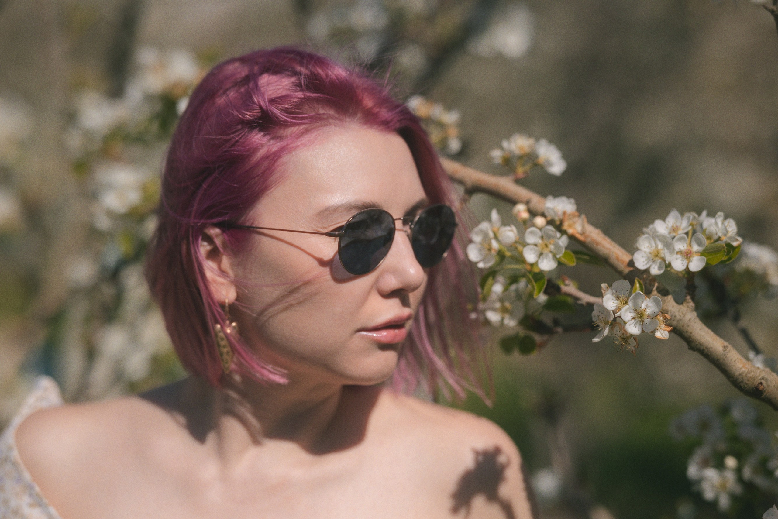 Elegant woman in a dress among blooming trees, spring photoshoot in Barcelona