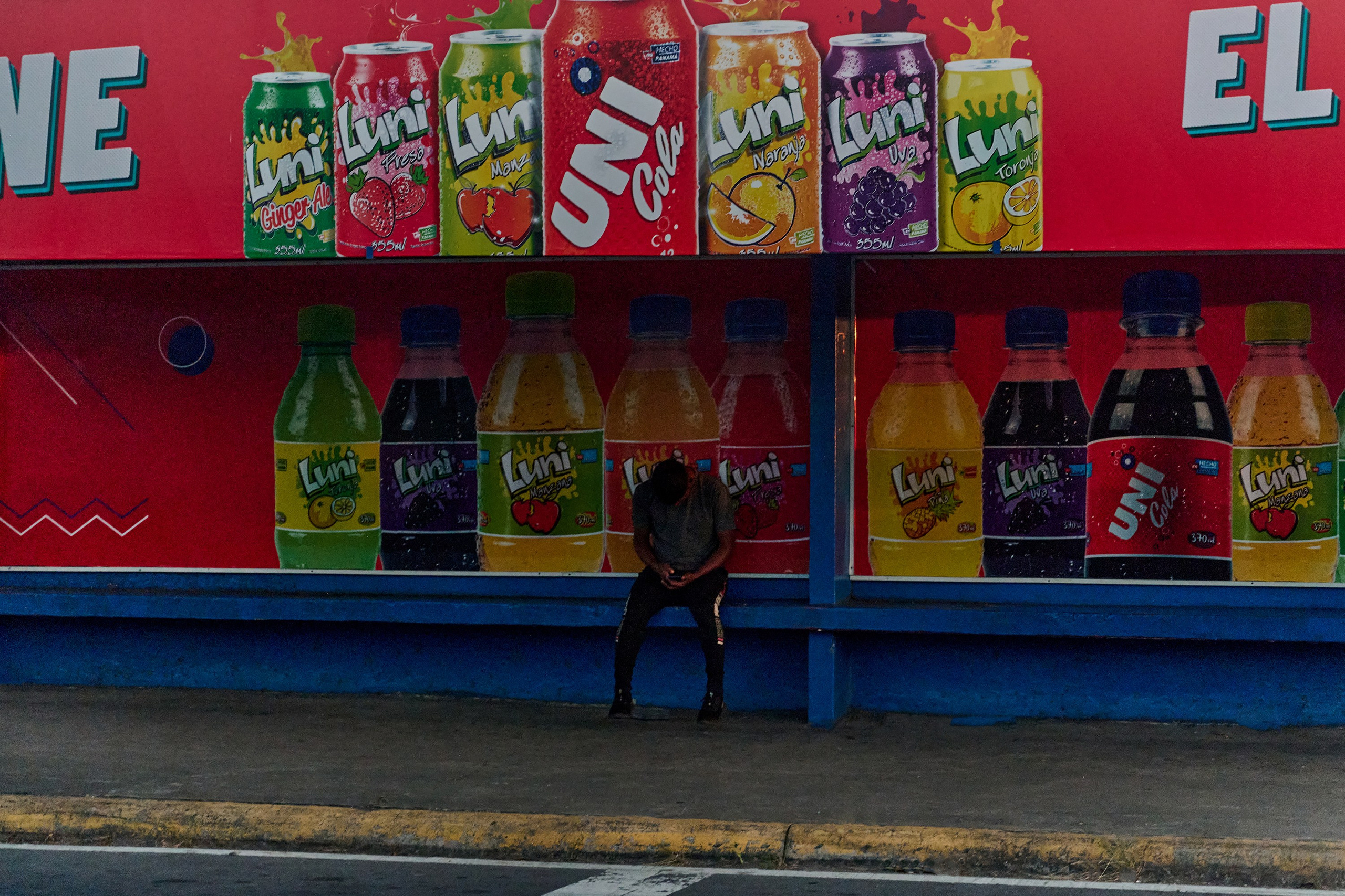 мужчина на автобусной остановке, сидит, смотрит в телефон, Панама, Давид, Panama, David