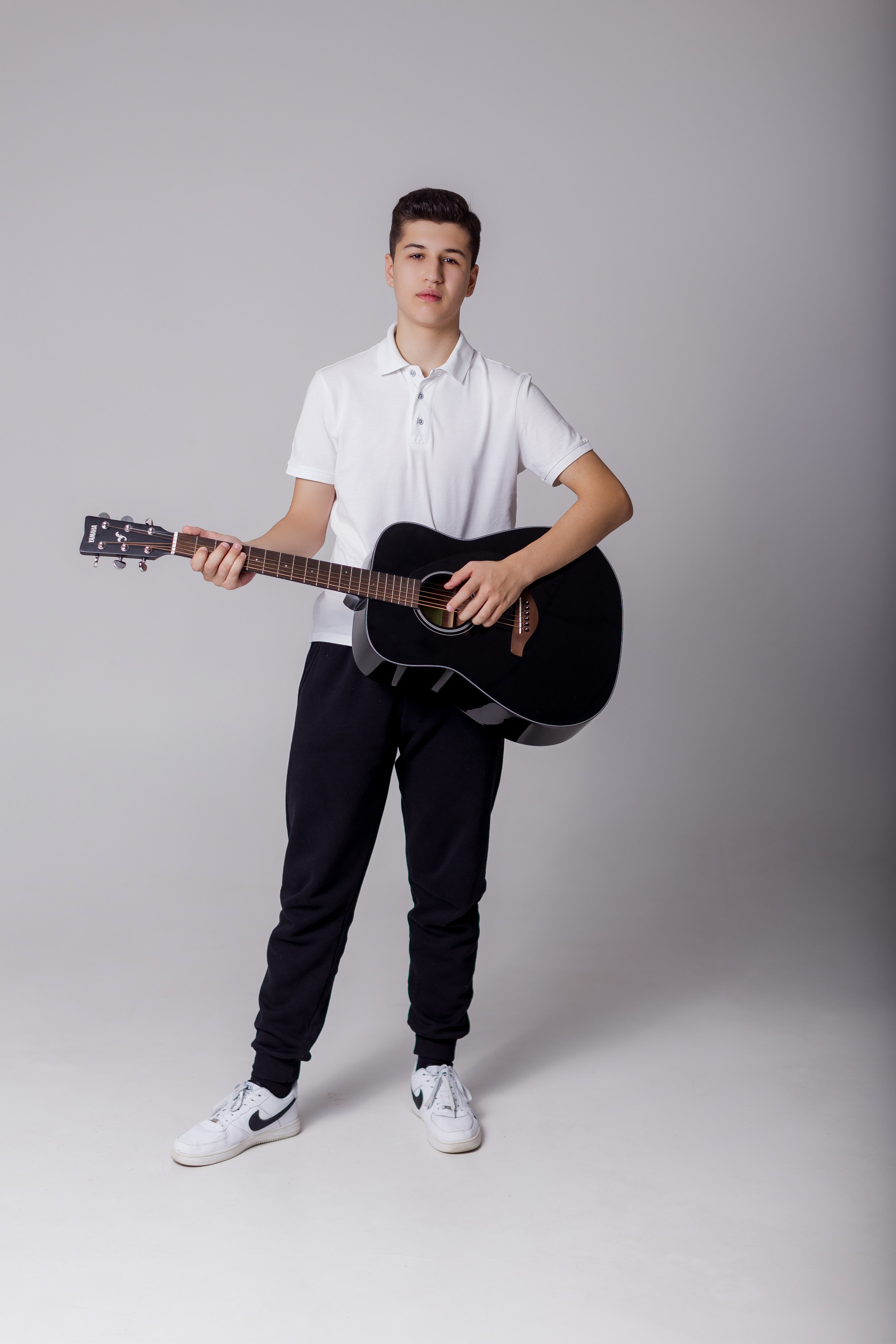 Молодой человек стоит с гитарой