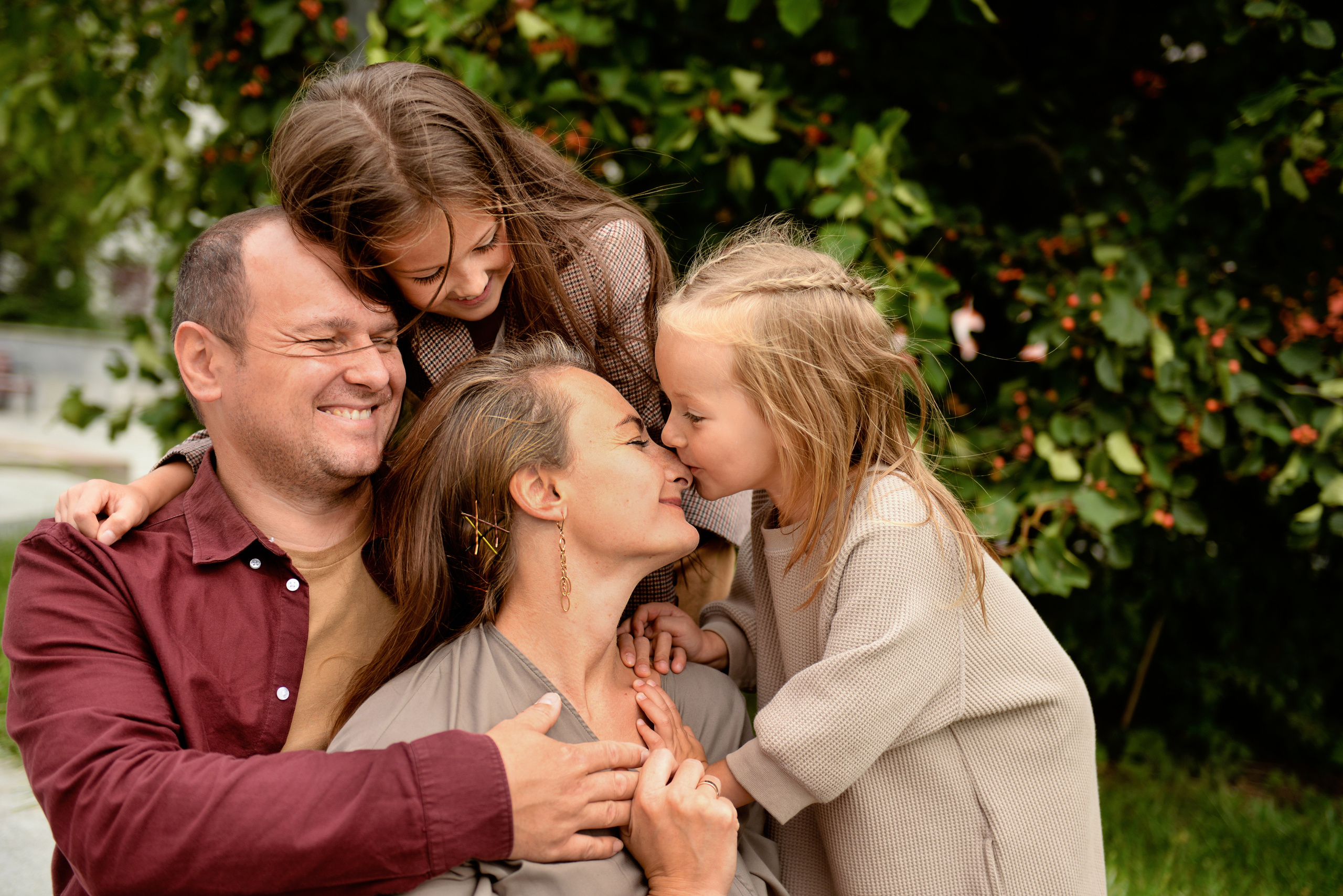 Папа, мама и две дочки обнимают друг друга. Счастливая семья