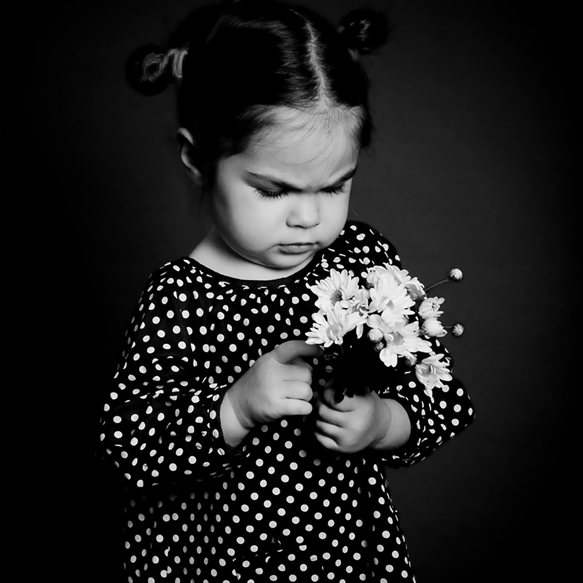 Студийный портрет красивой девочки с цветами, выполненный в черно-белом исполнении