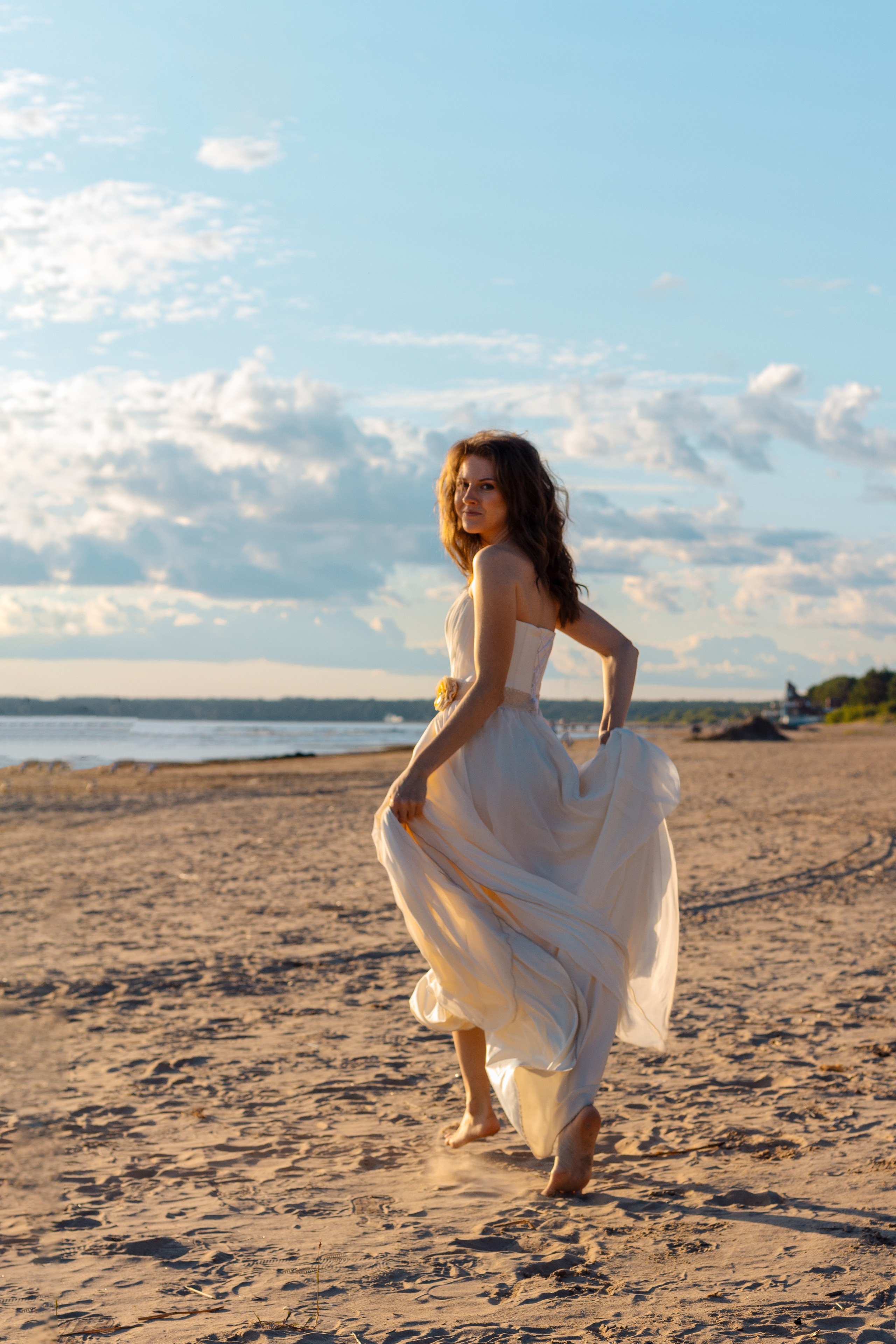 Девушка на берегу залива бежит вдоль берега. Фотосессия на берегу залива.