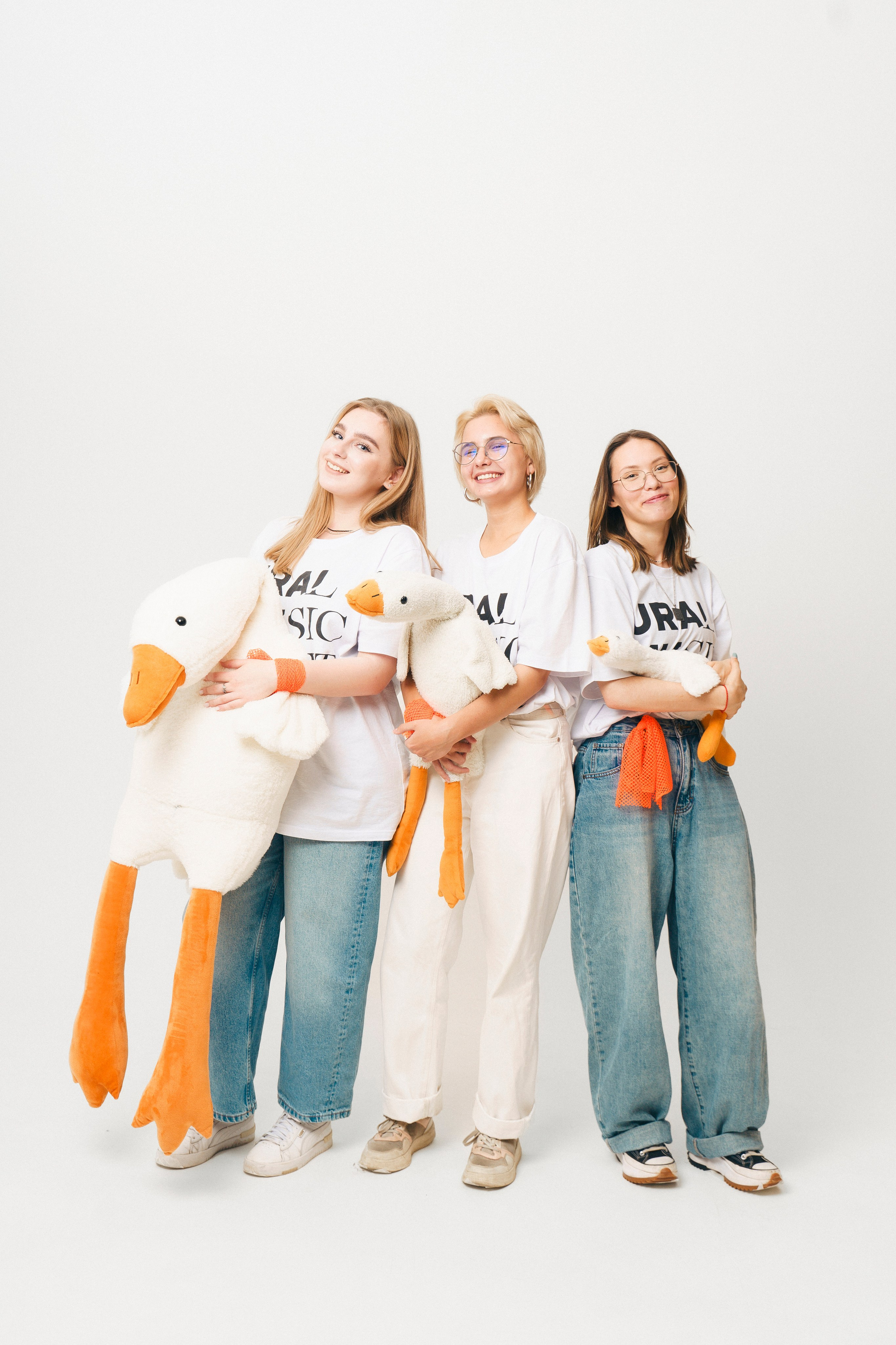 Молодые люди позируют с мягкой игрушкой гуся на съёмке