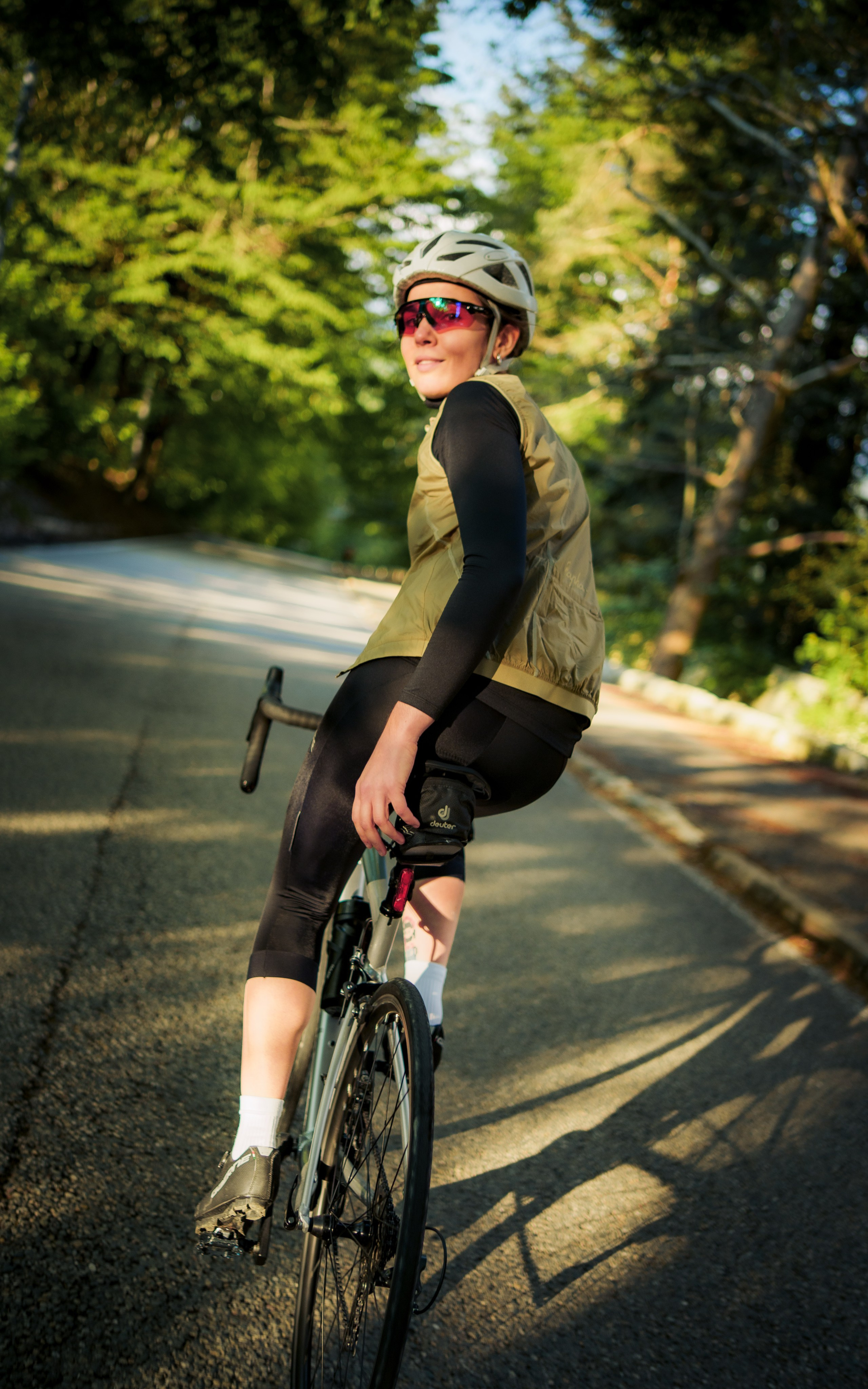 девушка едет на шоссейном велосипеде по горному серпантину