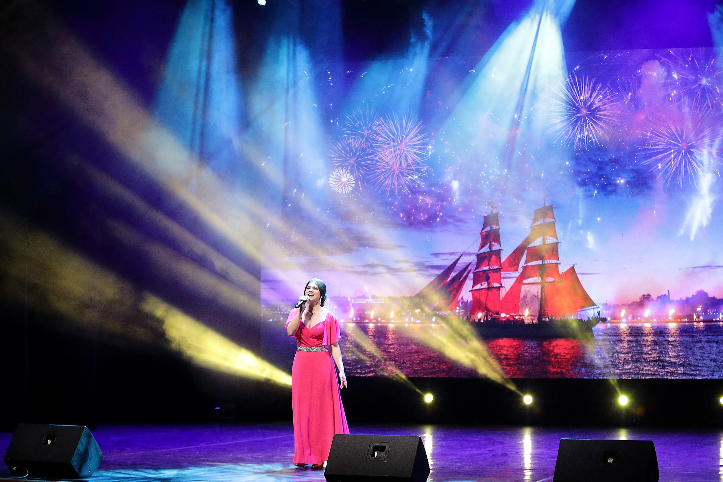 девушка в розовом платье поёт на сцене