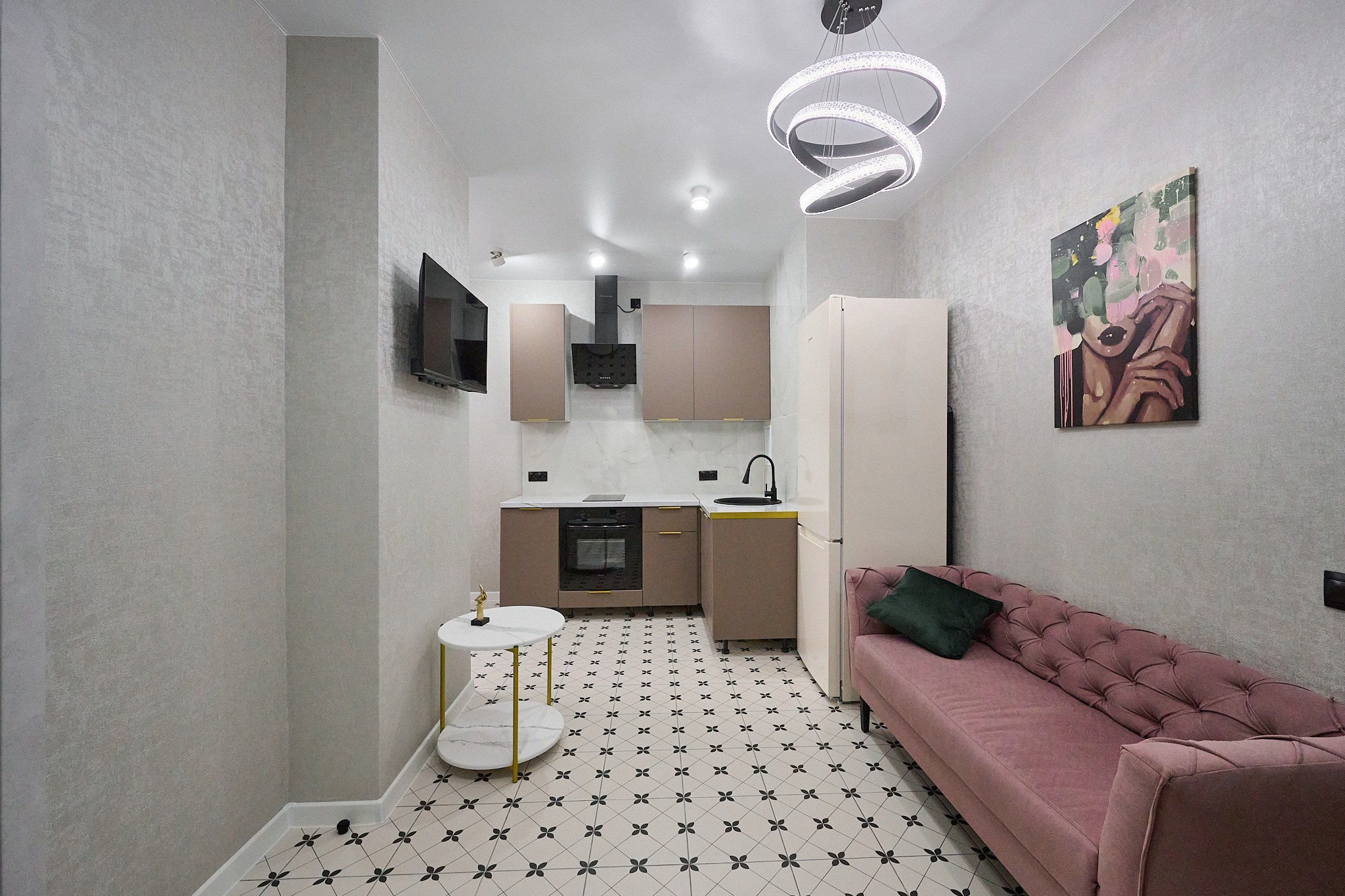 кухня кухонный розоватый диван белые стены пудровый цвет шкафов маленькая белая подставка стол 