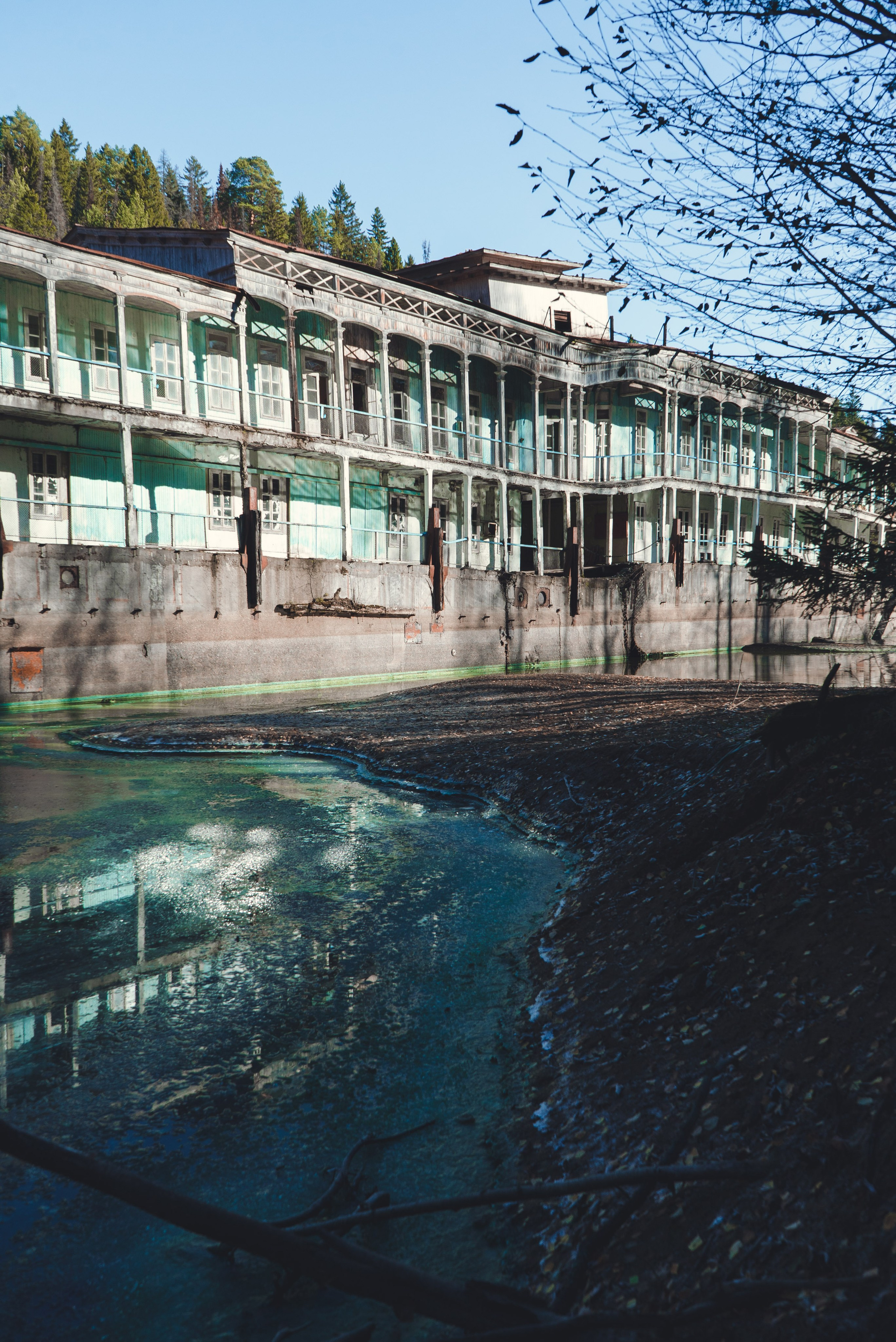 Заброшенное здание, виднеющееся на старинном берегу речной пароход, стоит на водоеме среди густого леса. Его фасад украшен колоннами и балконами, однако здание выглядит ветхим и запущенным: краска облупилась, металл покрыт ржавчиной. Вокруг голые деревья и хвойные леса, что создает ощущение уединенности и застенчивости.