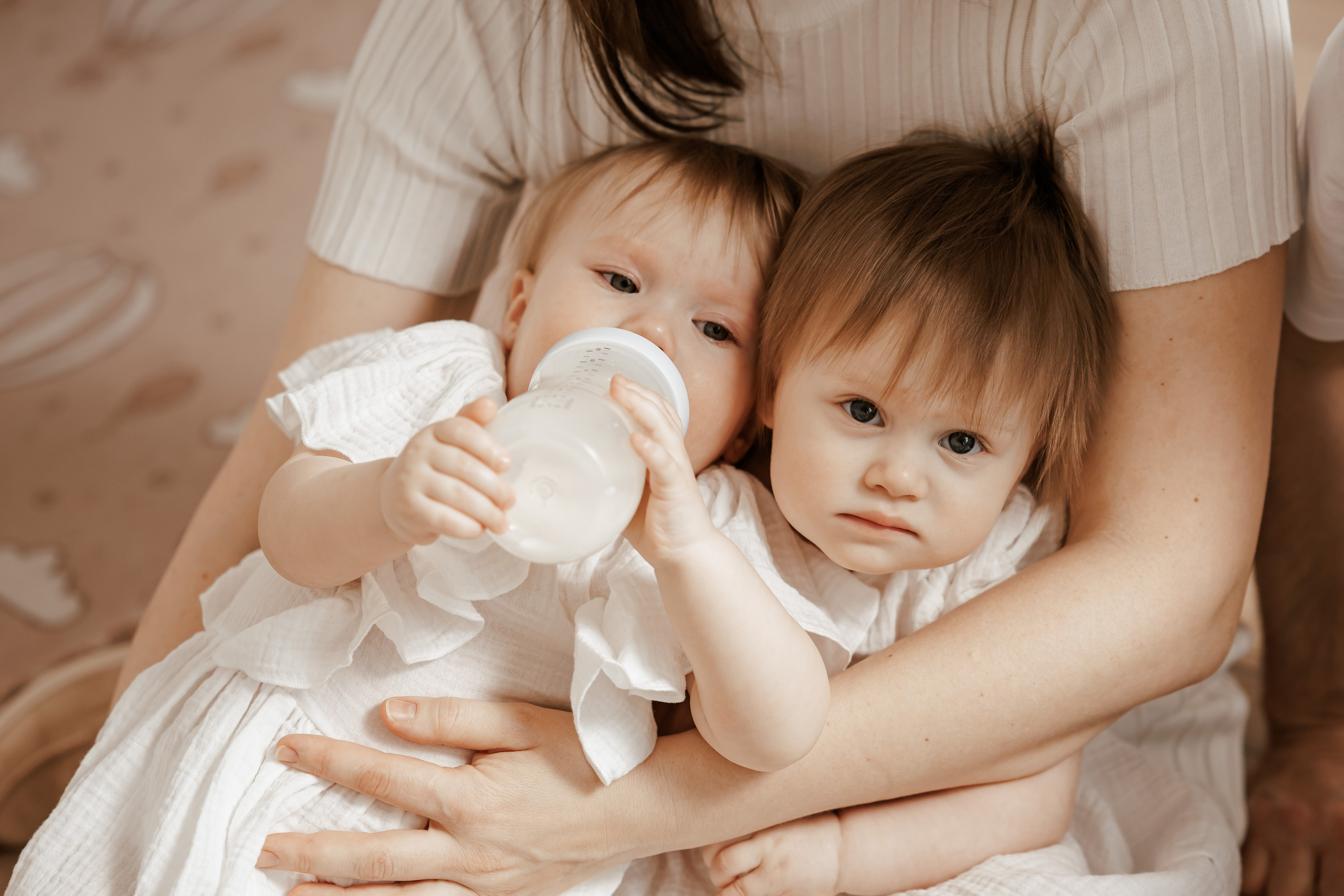 Семейная фотосессия для семьи с девочками близнецами на годик одежда в светлых тонах светлая бежевая студия в Москве теплые тона