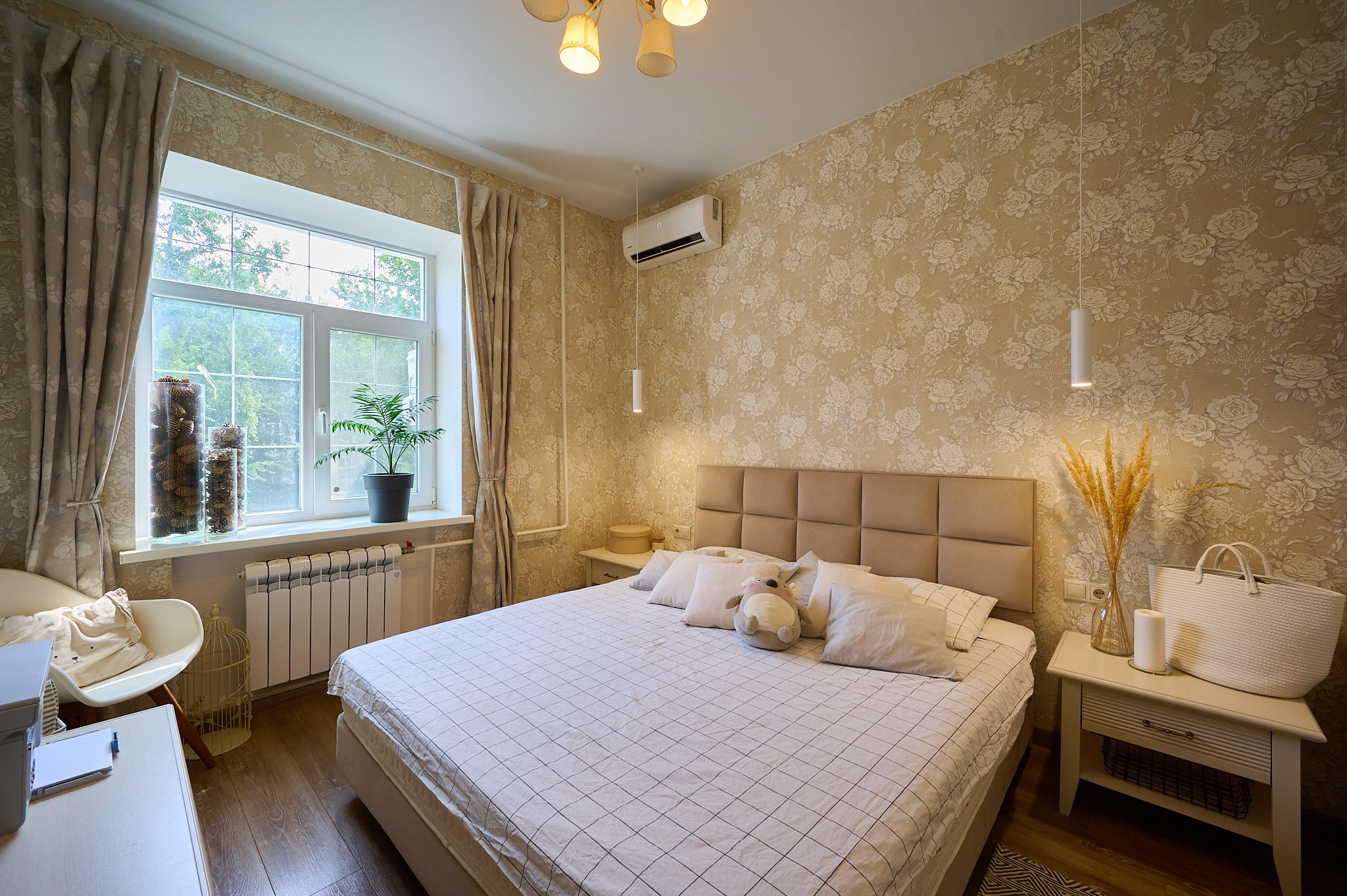 комната светлые оттенки бежевая кровать бежевые тумбы у кровати стол белый стул светлые шторы