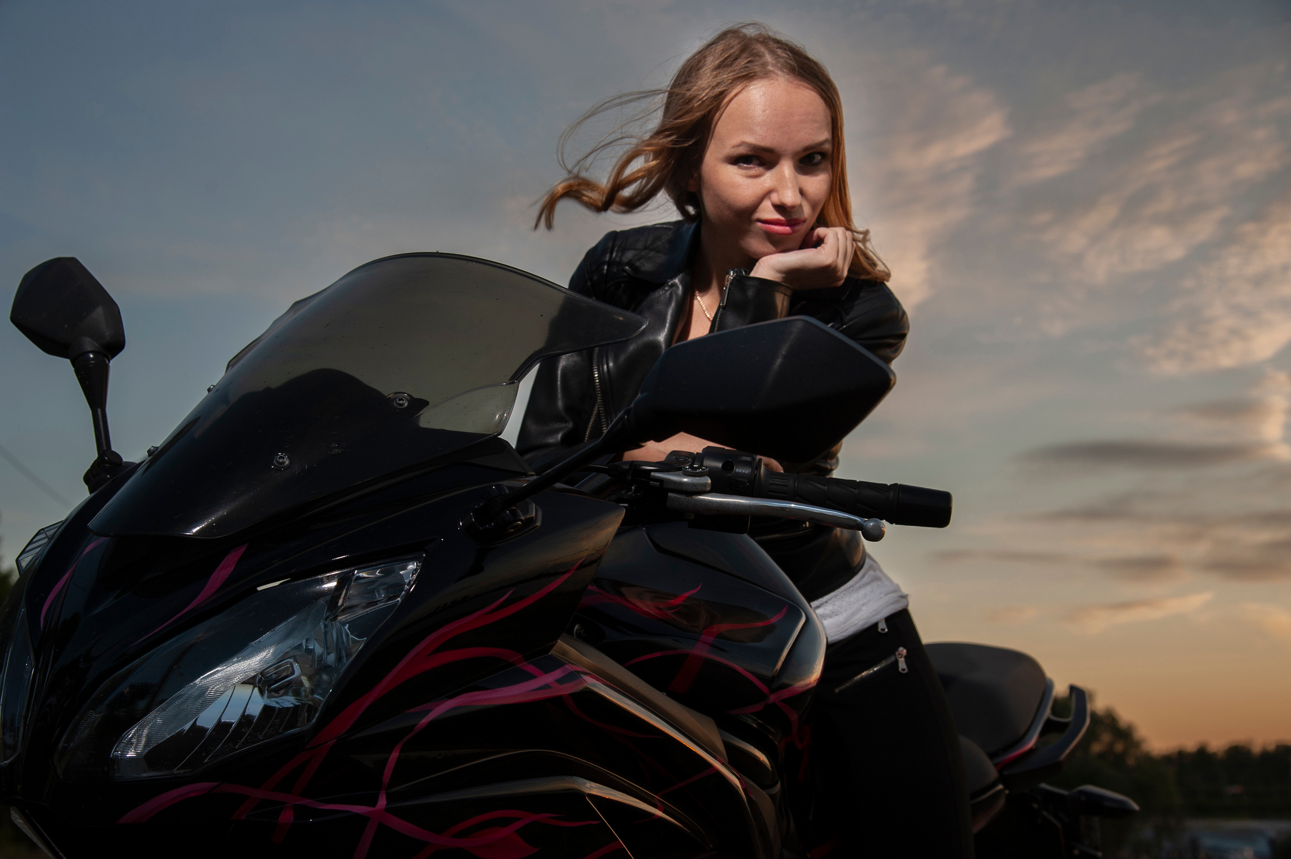 Девушка байкер на фоне летнего заката .