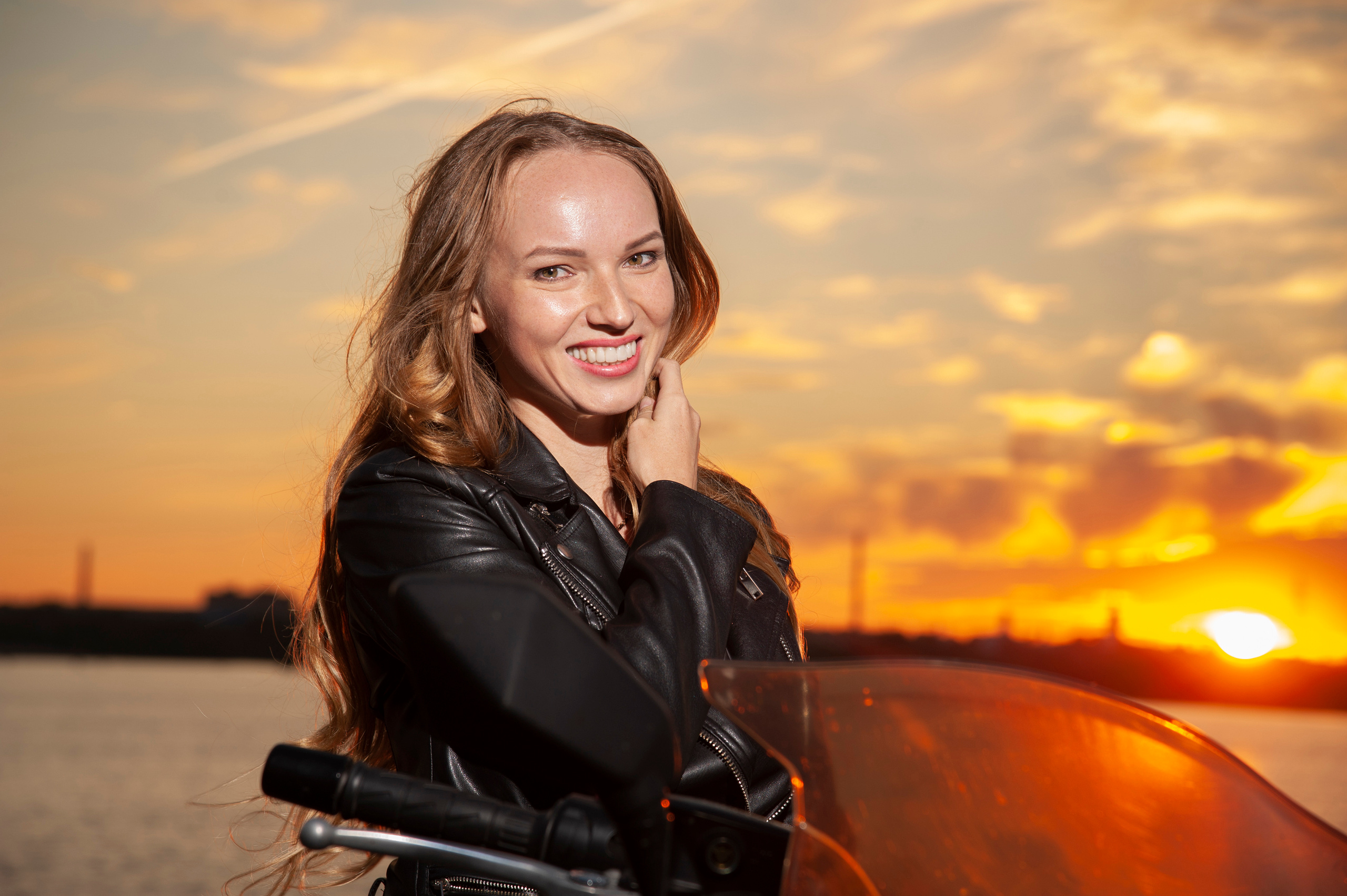 Блондинка байке на закате.