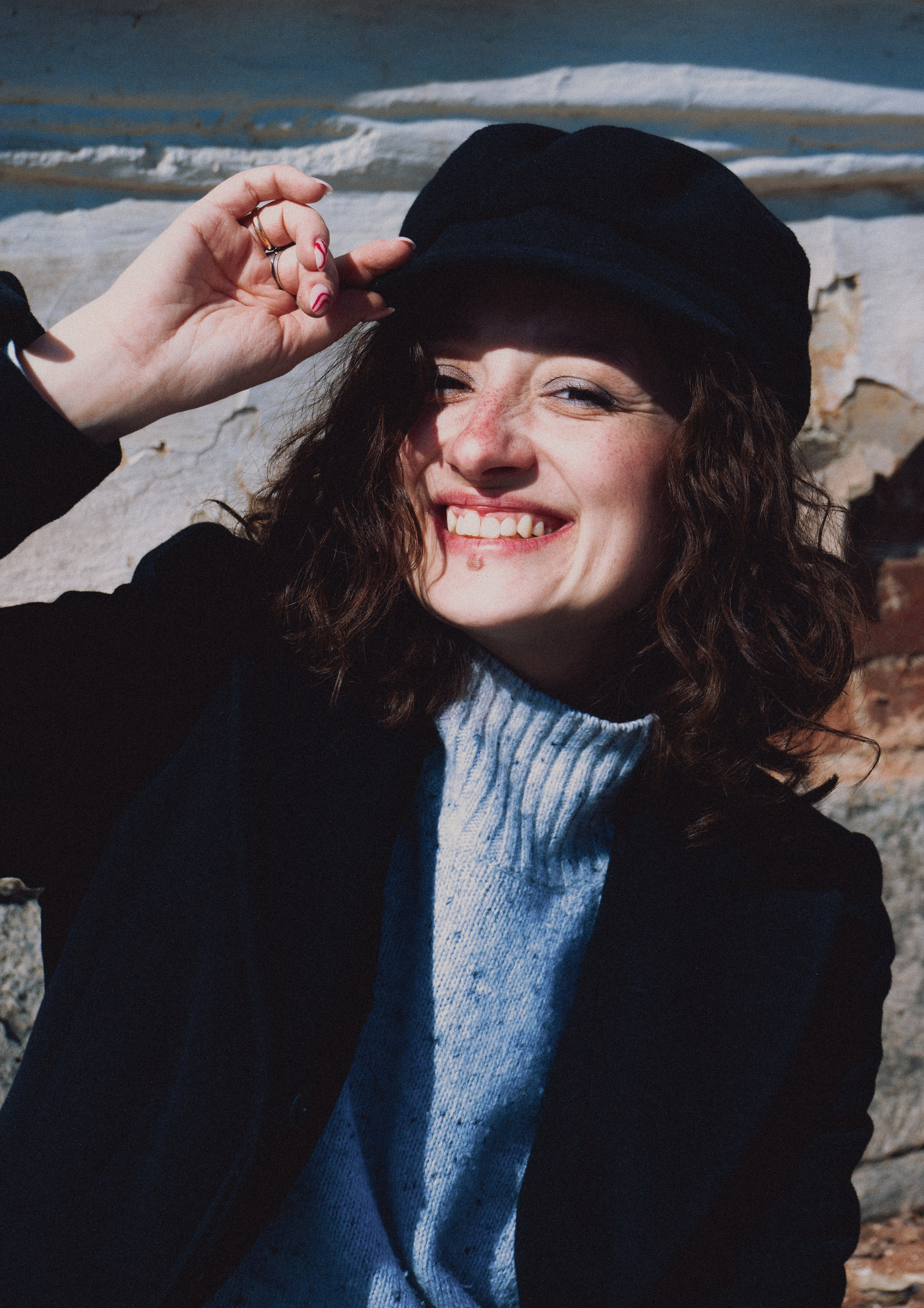 Девушка улыбается и держит панаму рукой