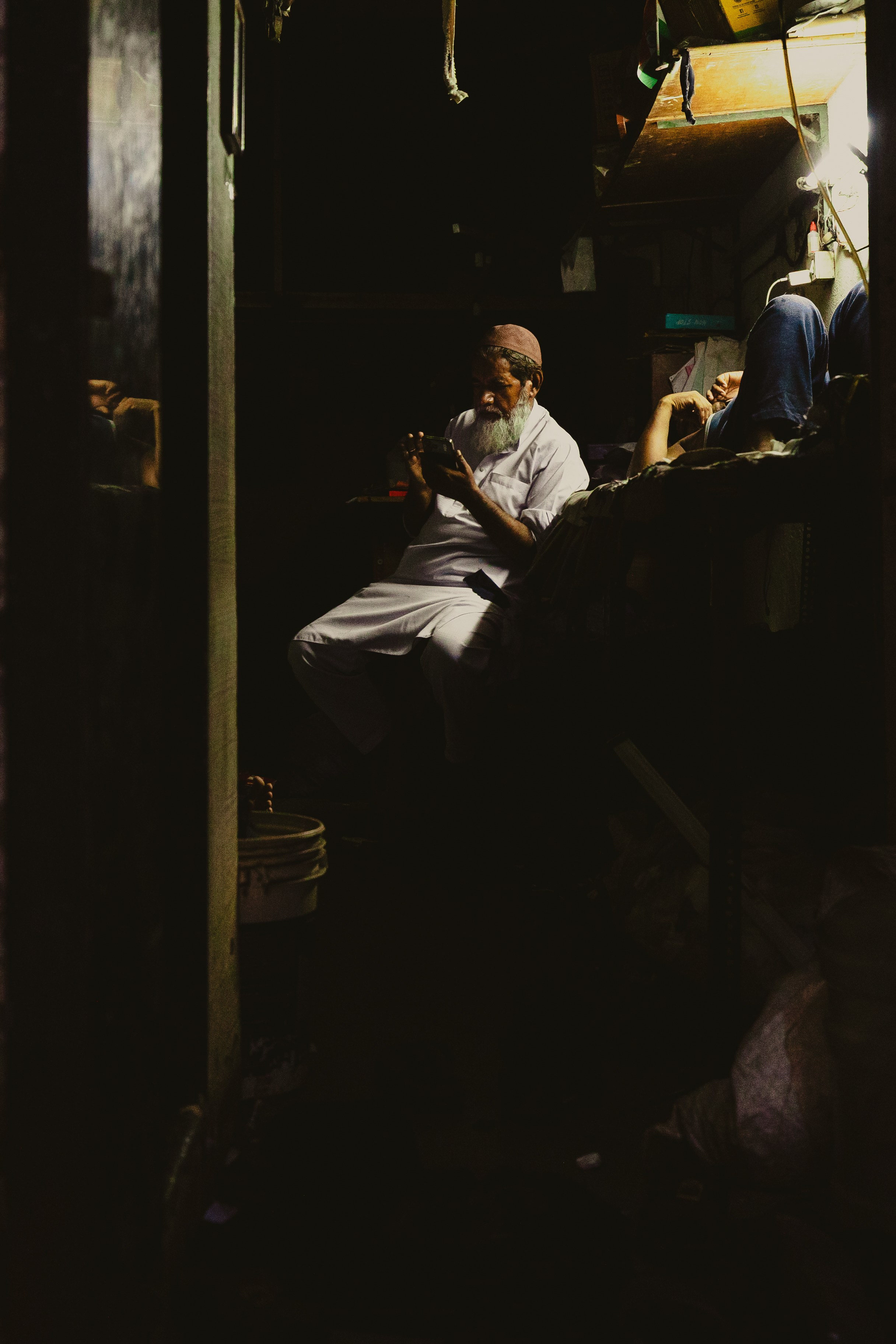 Мужчина-торговец в тёмном интерьере или вечерней обстановке