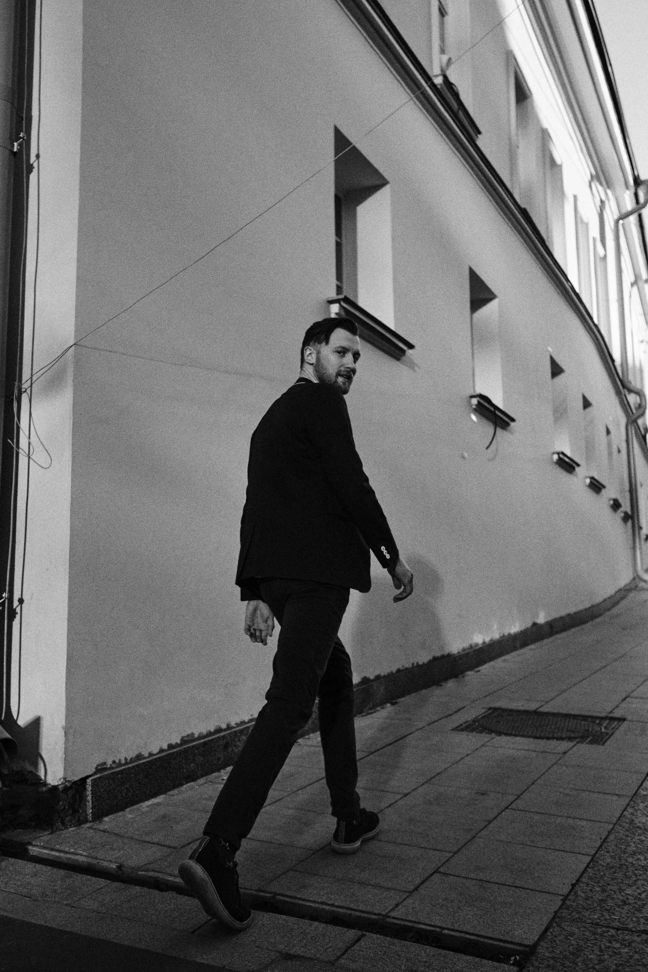 Мужчина идет по улицам города широким шагом