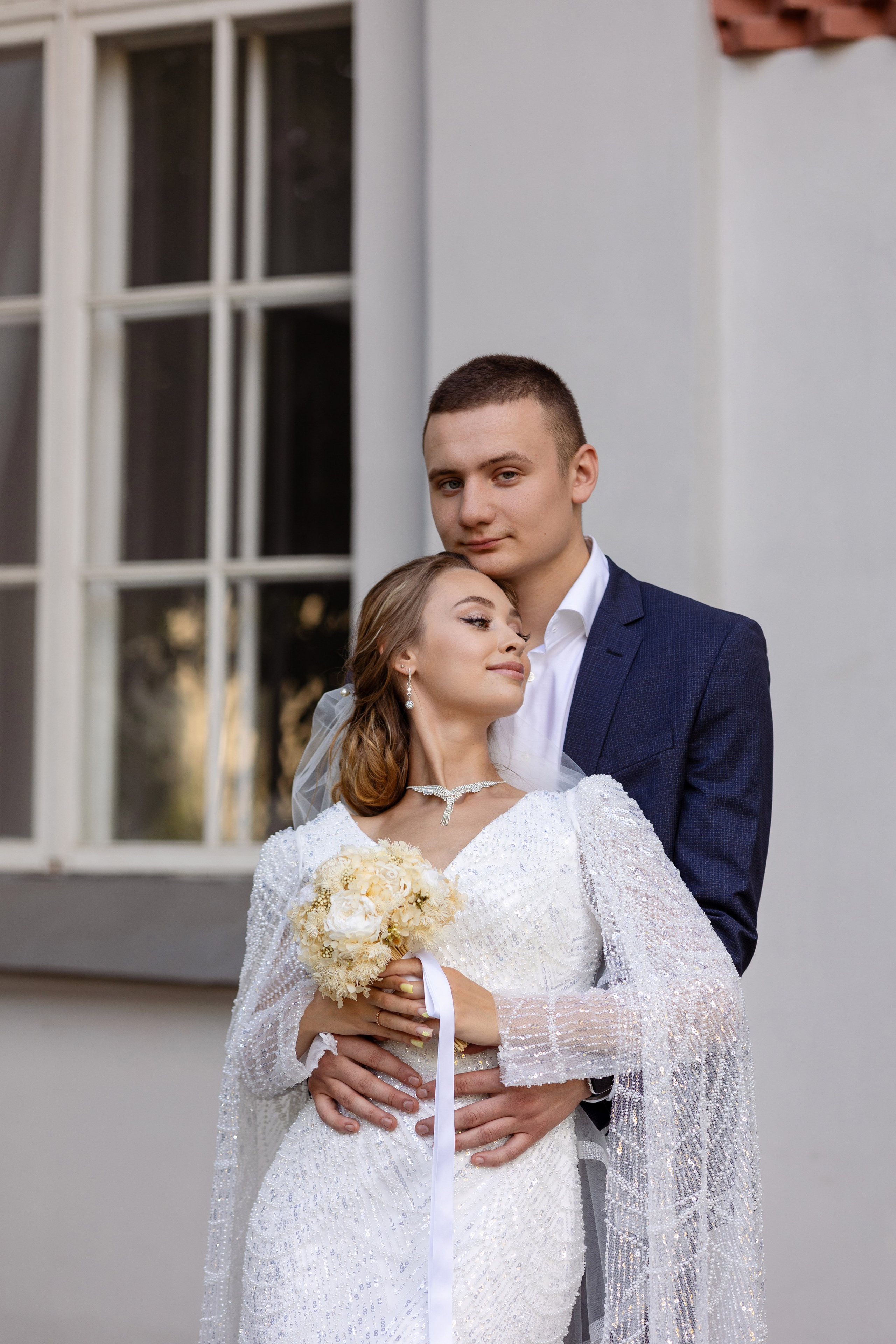 Молодые у окна, в руках невесты букет.