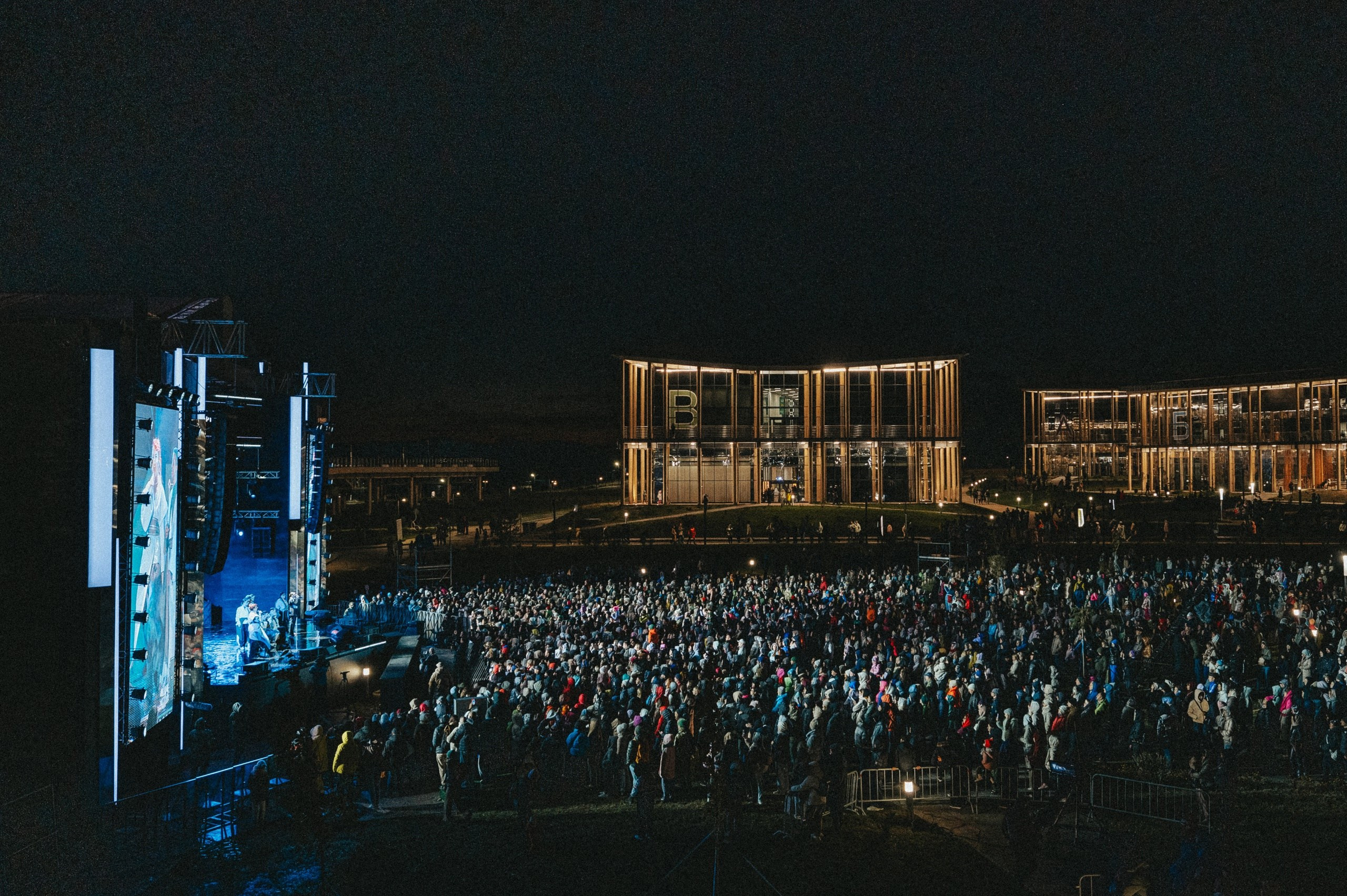 Общий масштаб концерта с толпой зрителей в ночное время