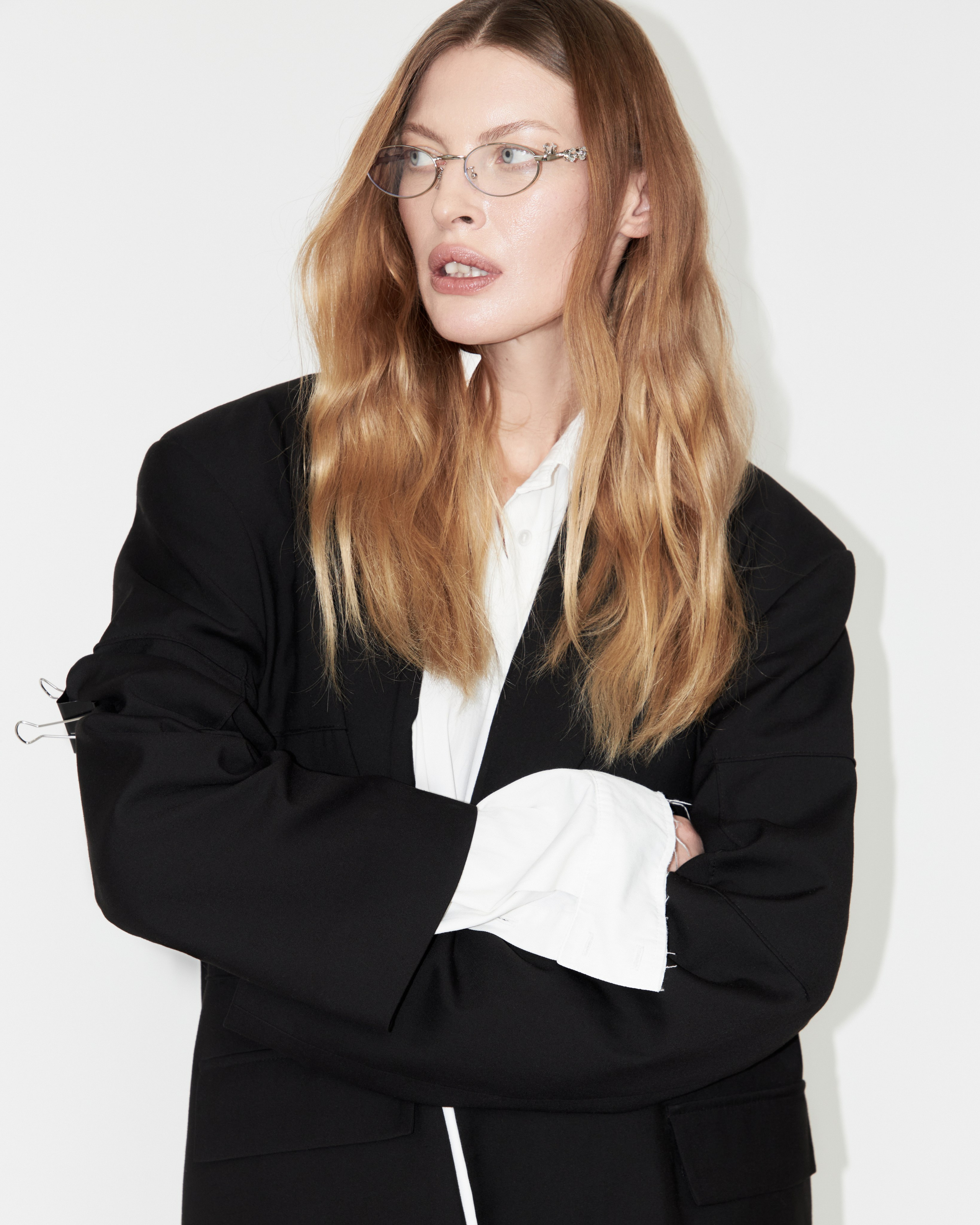 Женщина в черном пиджаке и классической белой рубашке в очках 