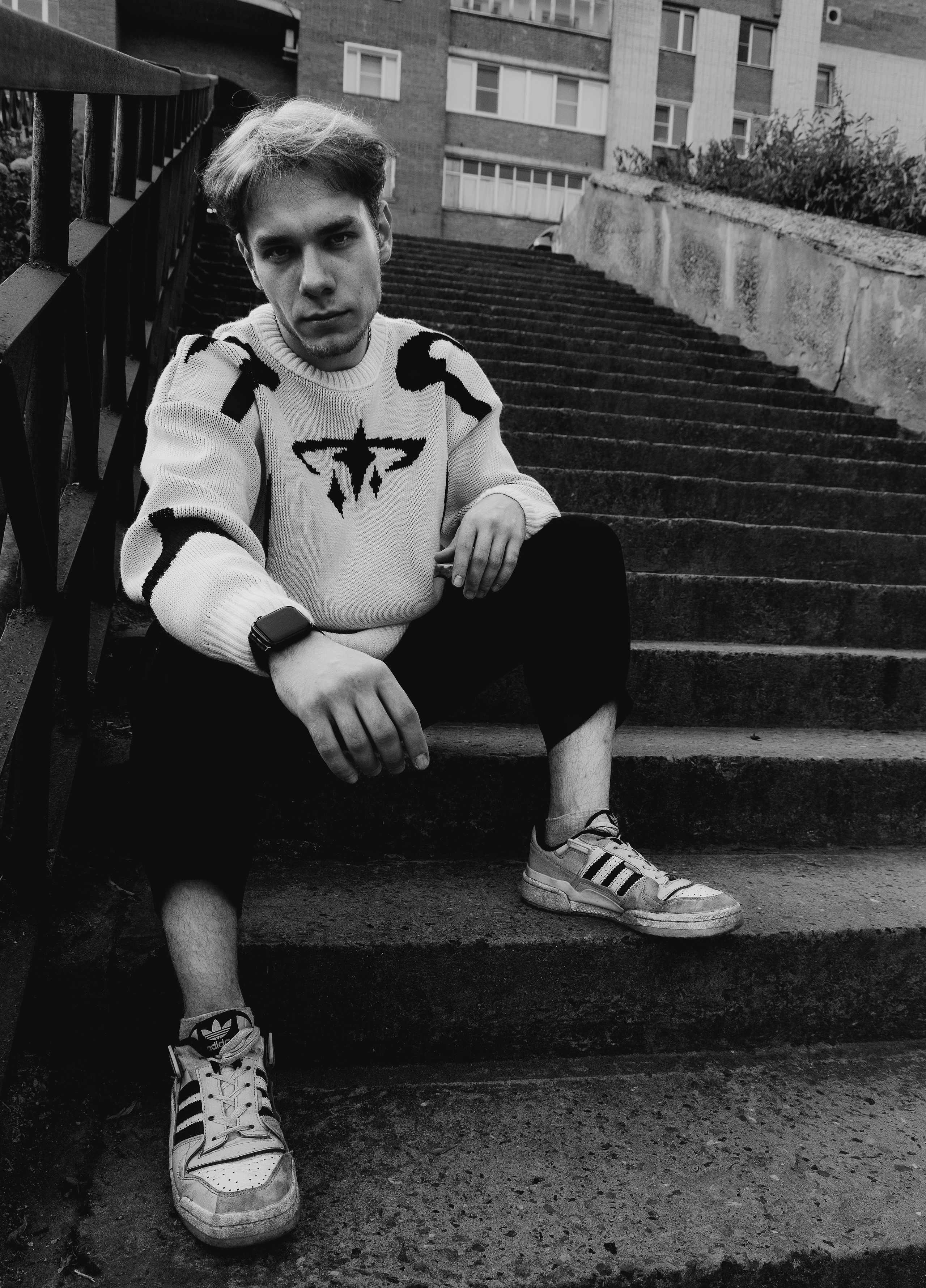 Серьезный парень сидит на лестнице