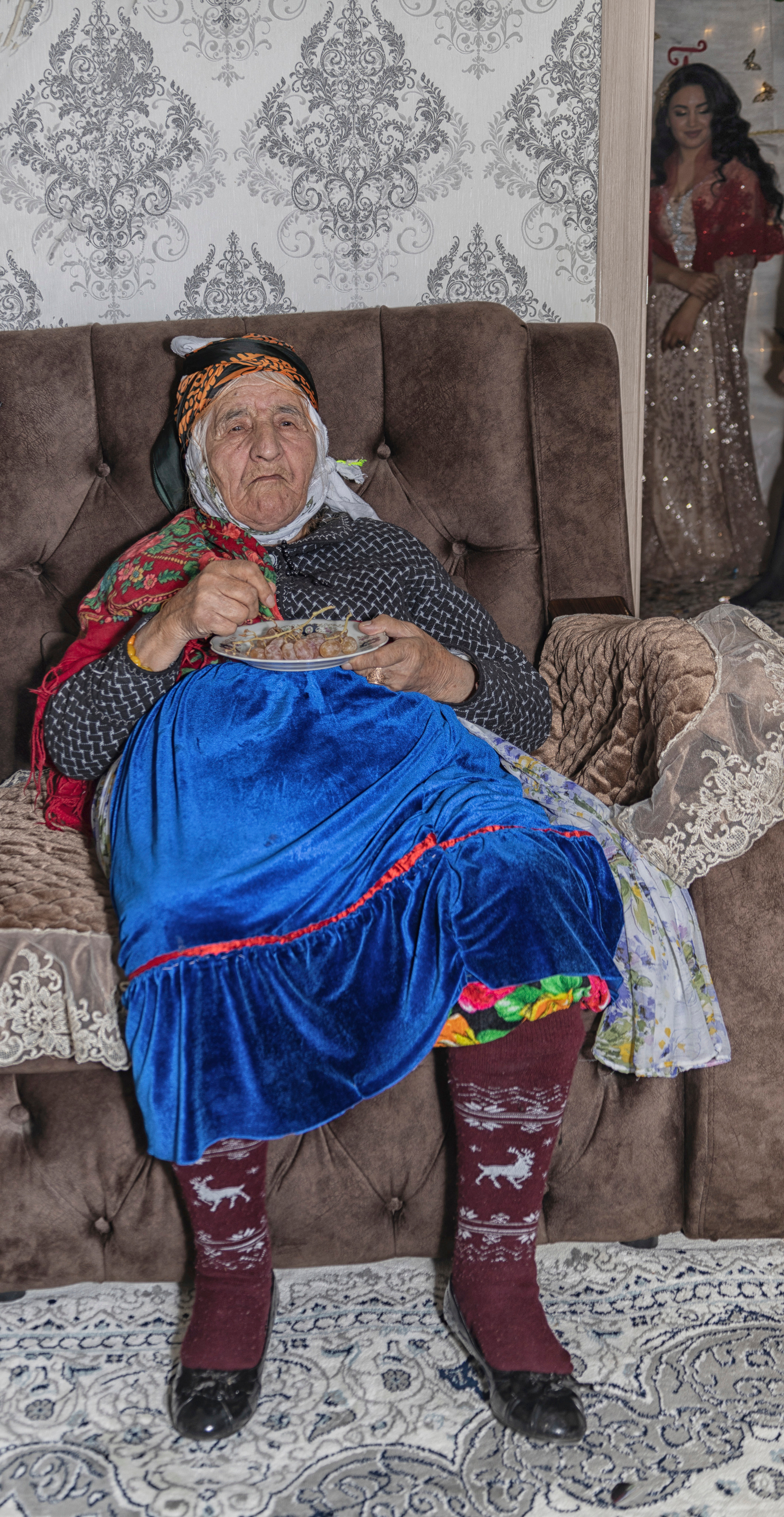 Старейшая женщина в семье жениха. Она одета вот в такой интересный, традиционный наряд. 