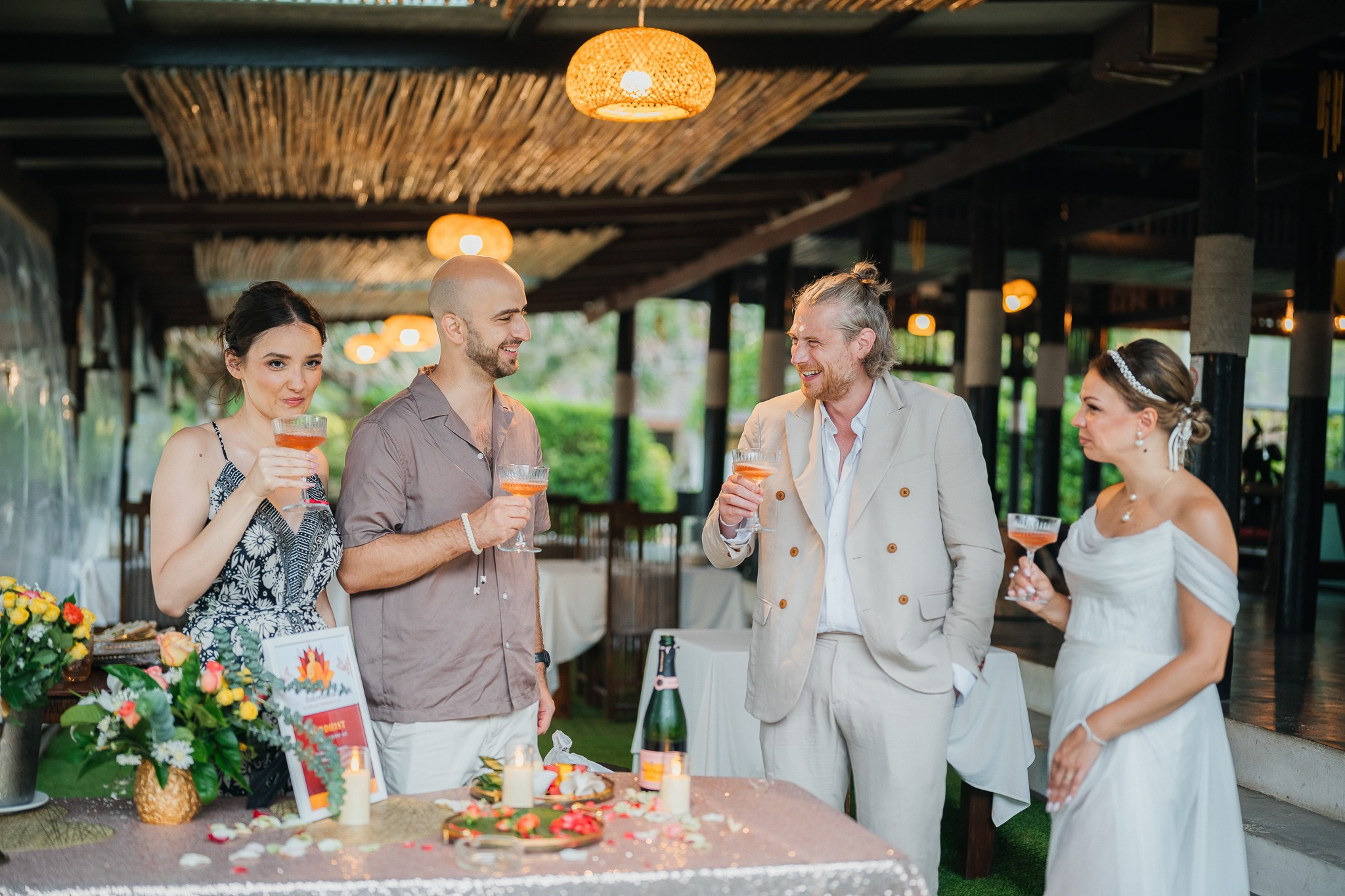 Newlywed couple celebrating a Buddhist wedding ceremony on a beautiful beach in Koh Samui, Thailand.
